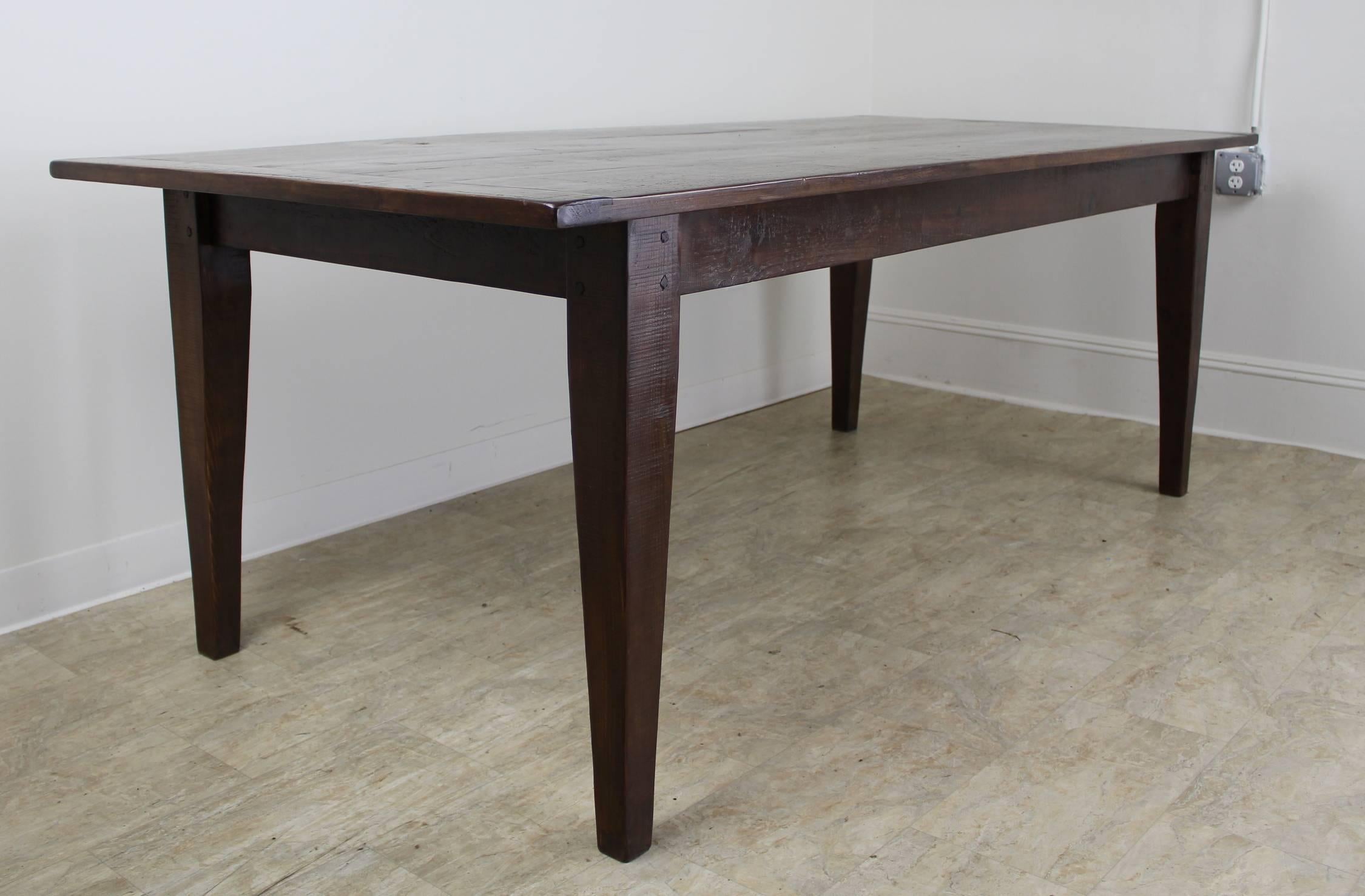 A generously proportioned, thick topped farm table in dark pine 7'. Great depth to the top. With 68 inches, between the legs, this table can easily fit eight with room for a Thanksgiving dinner as well! The apron height of 25 inches is good for