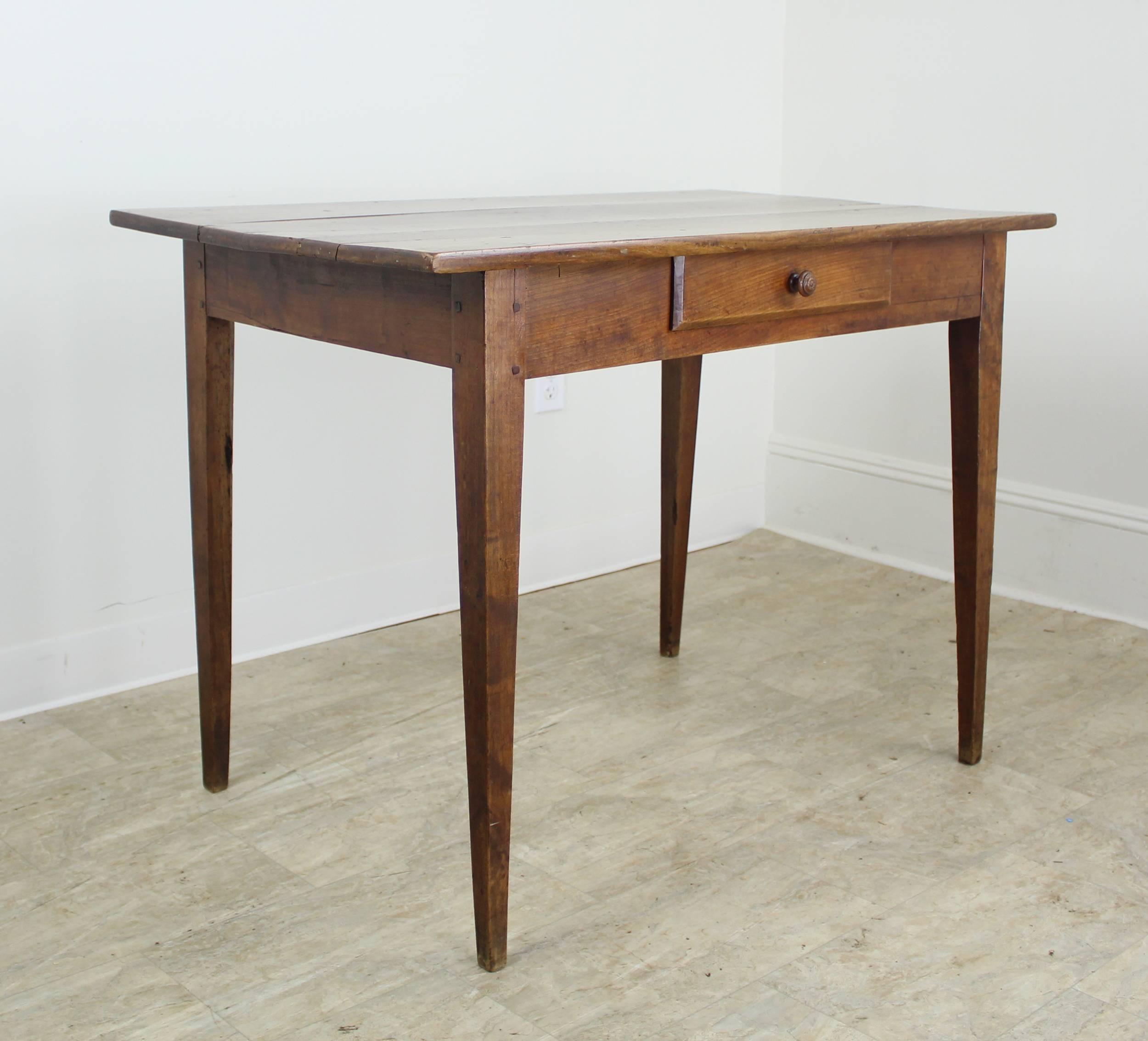 A refined writing table or desk in mellow cherry. Classic single drawer construction with tapered legs, lovely grain, and good patina. Measure: 24.5 inch apron height is good for knees. Very sturdy.