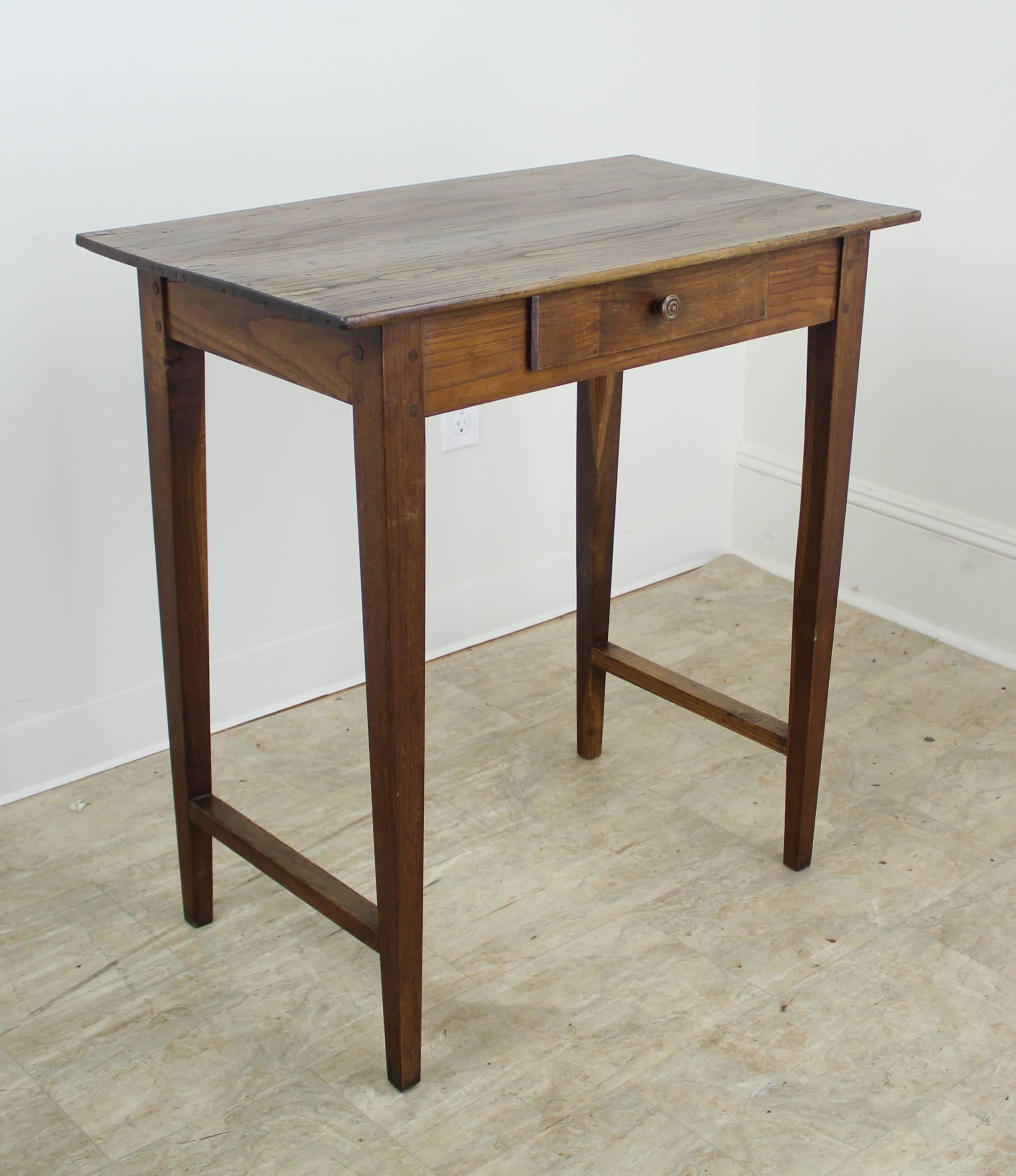 A tall elegant chestnut side table with stretchers at the bottom. The unusual height and single divided drawer make this just right for an entrance hall or as a nightstand next to a high, lofty bed. Wonderful color, grain and patina!