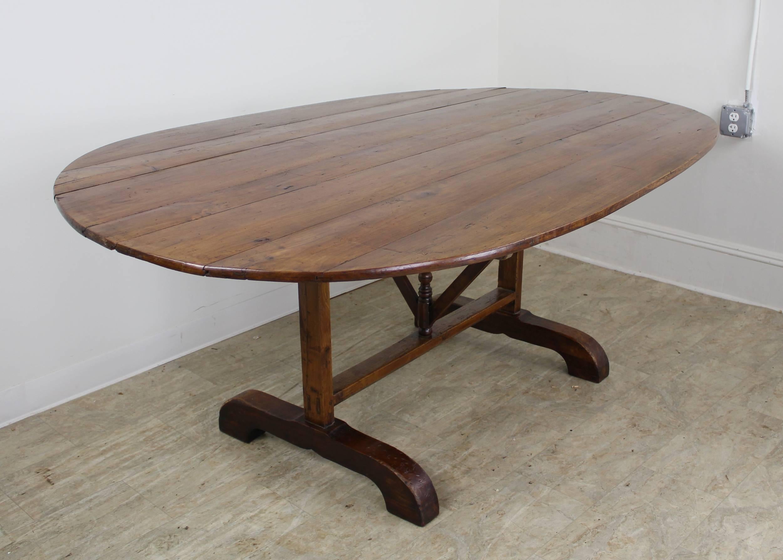 Unusually large wine tasting table from France.  This is a most attractive oval dining table, with excellent seating capacity.  It has a lovely cherry color with great grain and patina.  If desired it is easily secured in an open position to insure