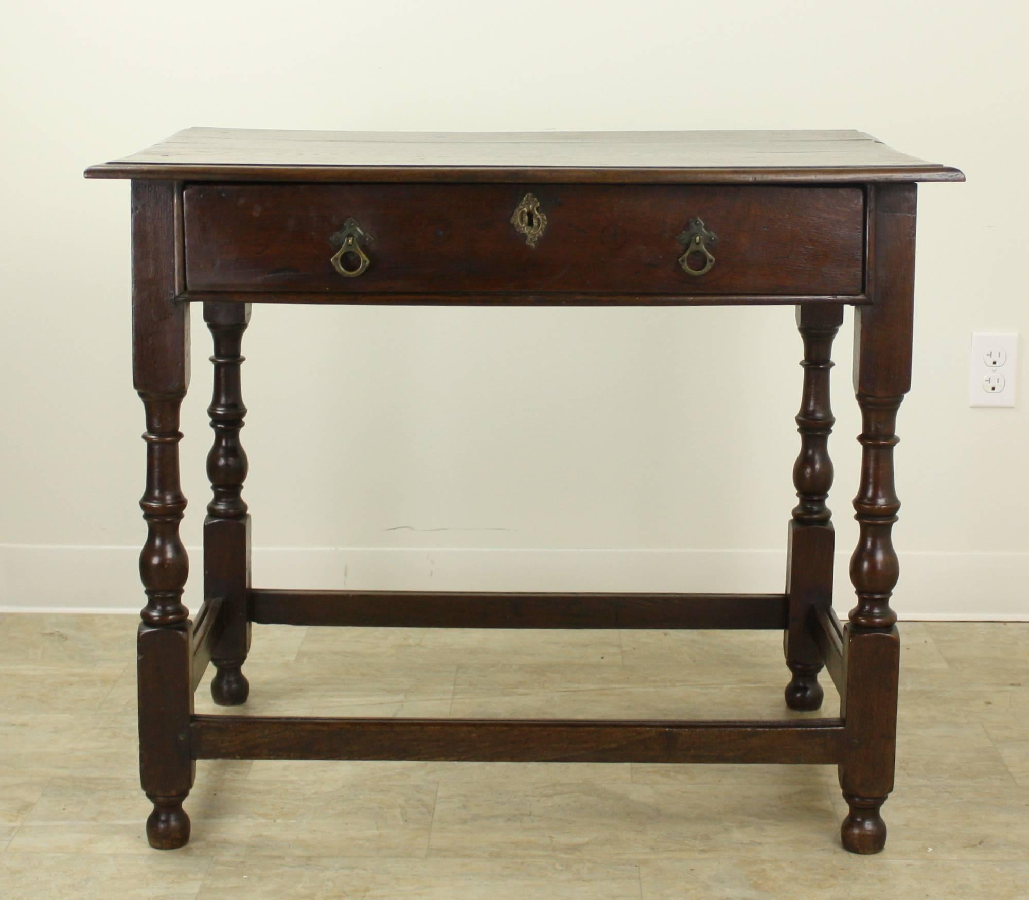 A handsome and generously proportioned period oak side or occasional table from Wales.  The top and legs are in very good condition for a piece of this age.  The wood is rich and dark with nice patina, and the single wide drawer is roomy and slides