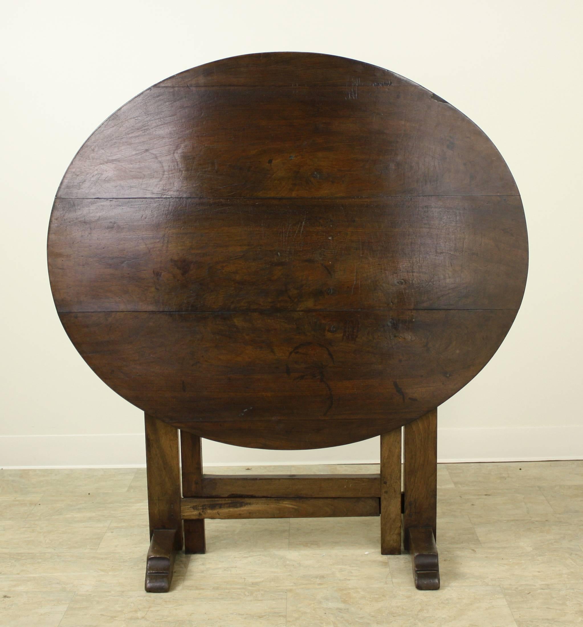 Charming smaller dining table, or breakfast table. A rich walnut hue allows the attractive grain to show. The legs' sledge feet allow the table to be strong and sturdy and support the table top. As is traditional, this wine tasting table has a top