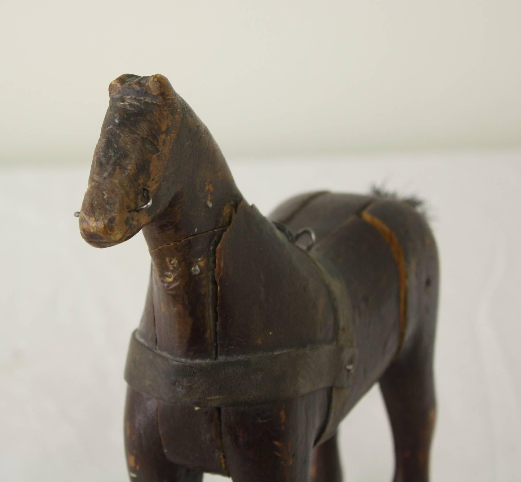This is a nice chunky horse, with parts of a harness, reins and bit.  And a charming short tail (probably fairly new).  In original paint, this is a smaller horse, which has the look of a primitive, home-carved piece.  A delightful shelf display