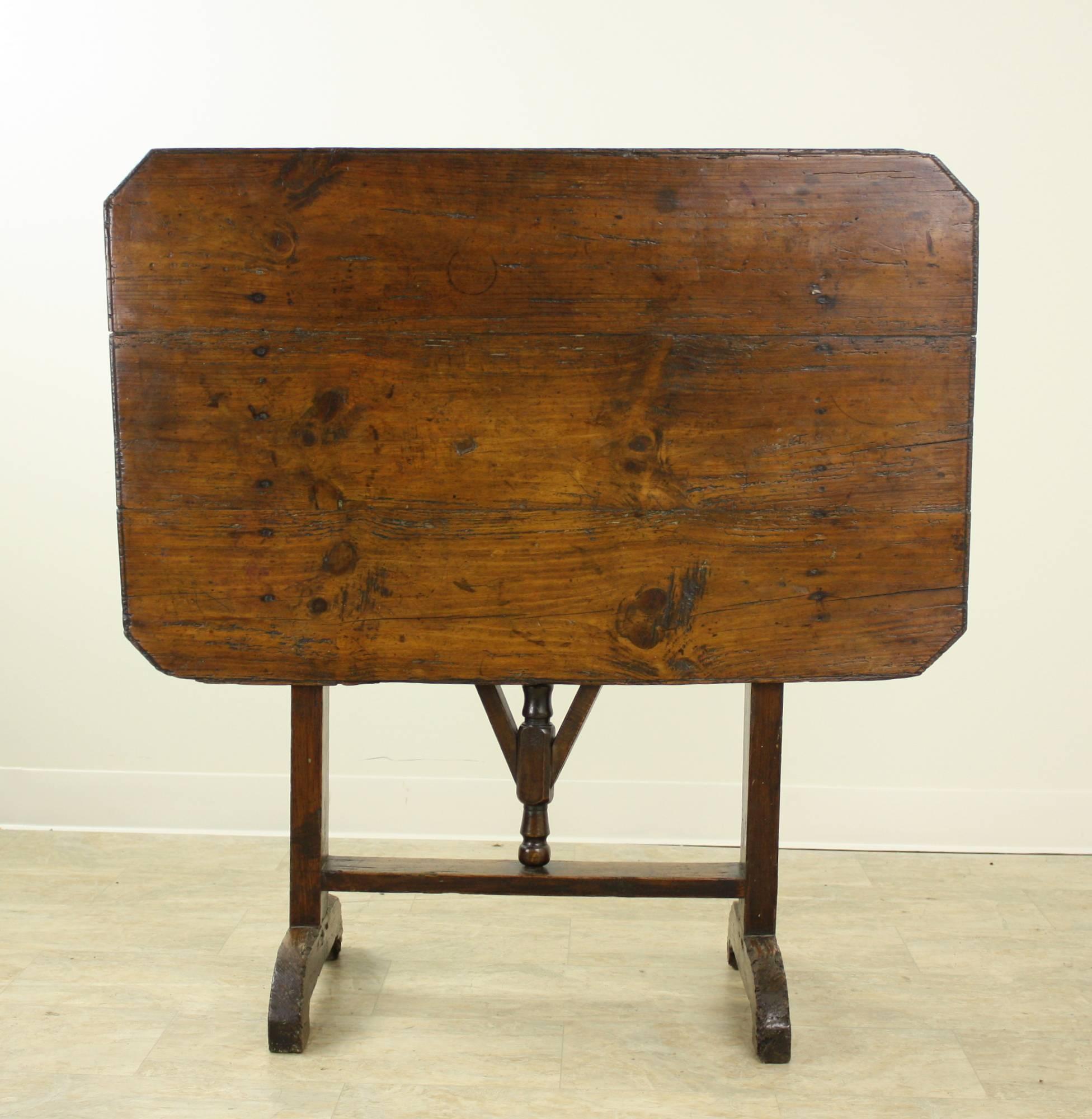 The distressed graining on this pine vendange wine tasting table is quite wonderful, and unusual to find with a rectangular top. The top has a lovely patina and a good carved edging. The swivel table base is easy to use, sturdy, and well turned. The