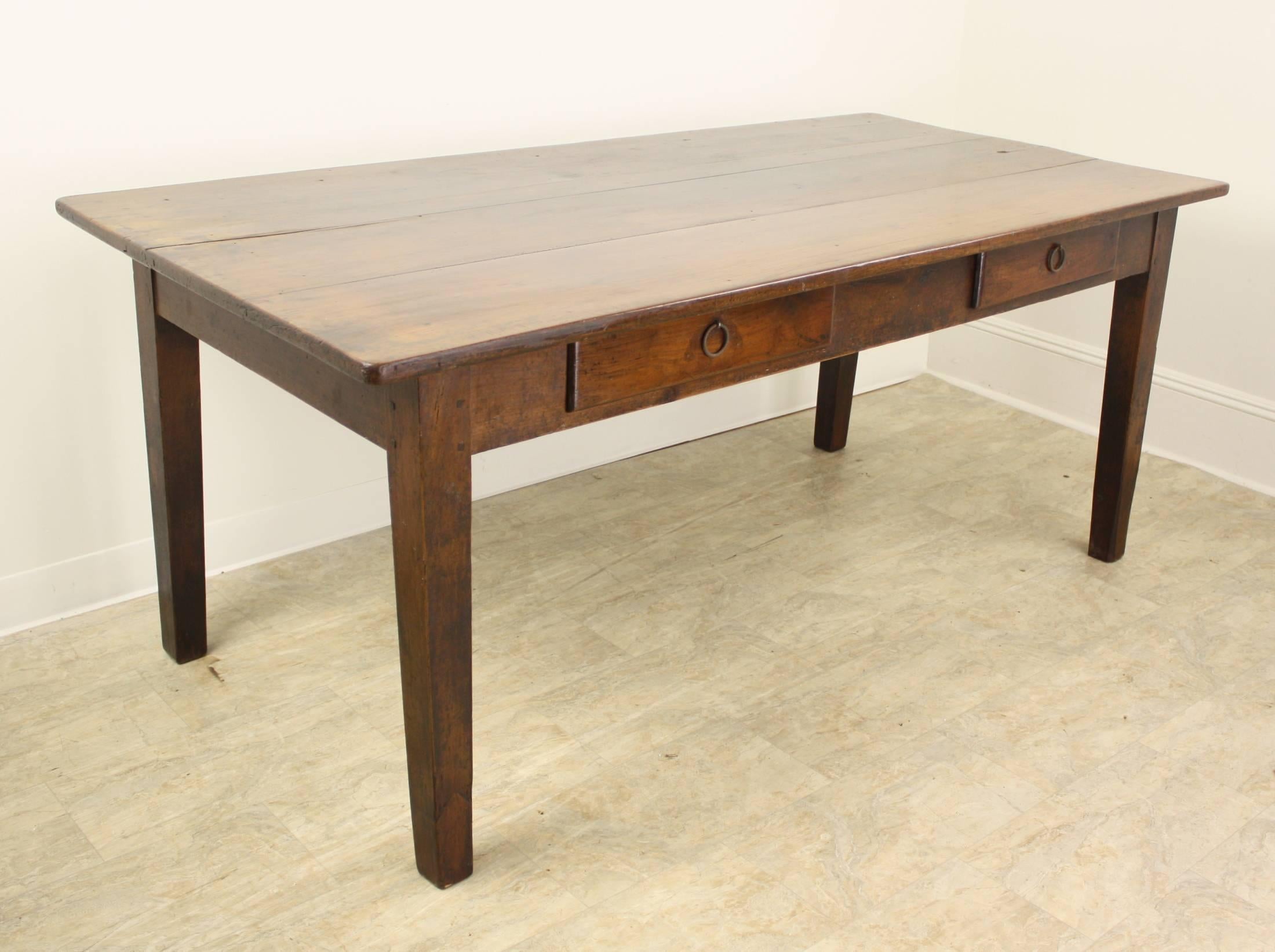 Six feet long, with a nice depth, this very attractive French cherry farm table offers a beautiful color and patina, and two drawers in the apron on one long side. Legs are Classic tapered slender legs. The apron height is a good comfortable 24