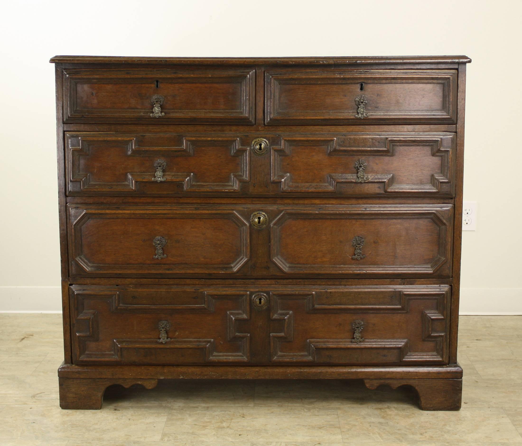 Dating from circa 1740, this large and stunning Classic Jacobean chest of drawer's is dramatic and unique. Two top drawer's atop three roomy bottom drawer's. The panels all around the body of the chest are very impressive. Diagonal patterns on the