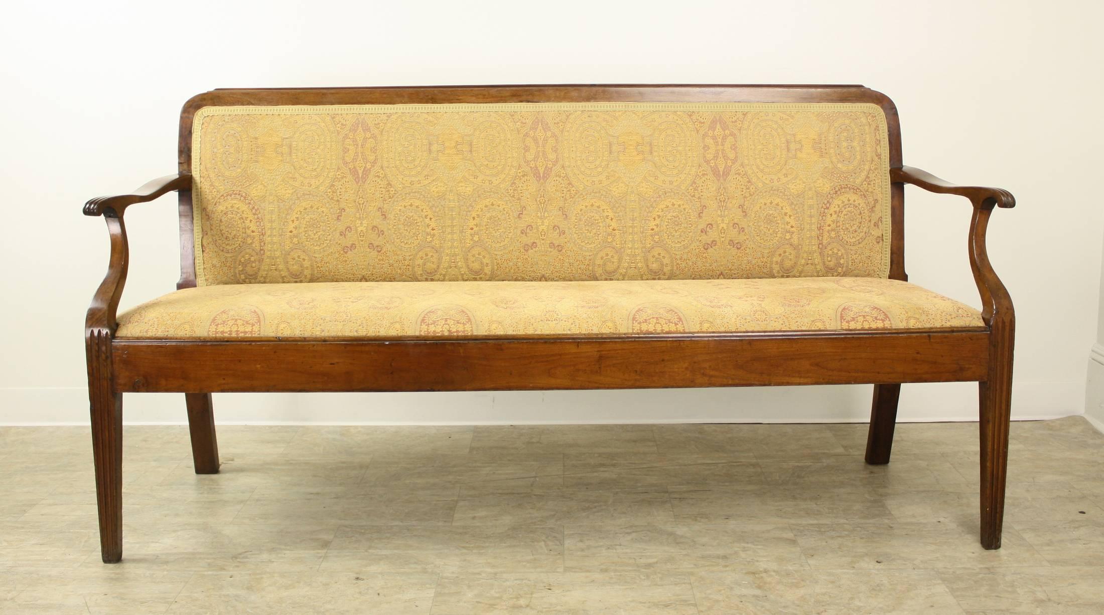 A slim and elegant fruitwood sofa in wonderful a condition for its age. Classic Scandanavian carved accents on the arms and legs. We love that the piece is upholstered front and back!