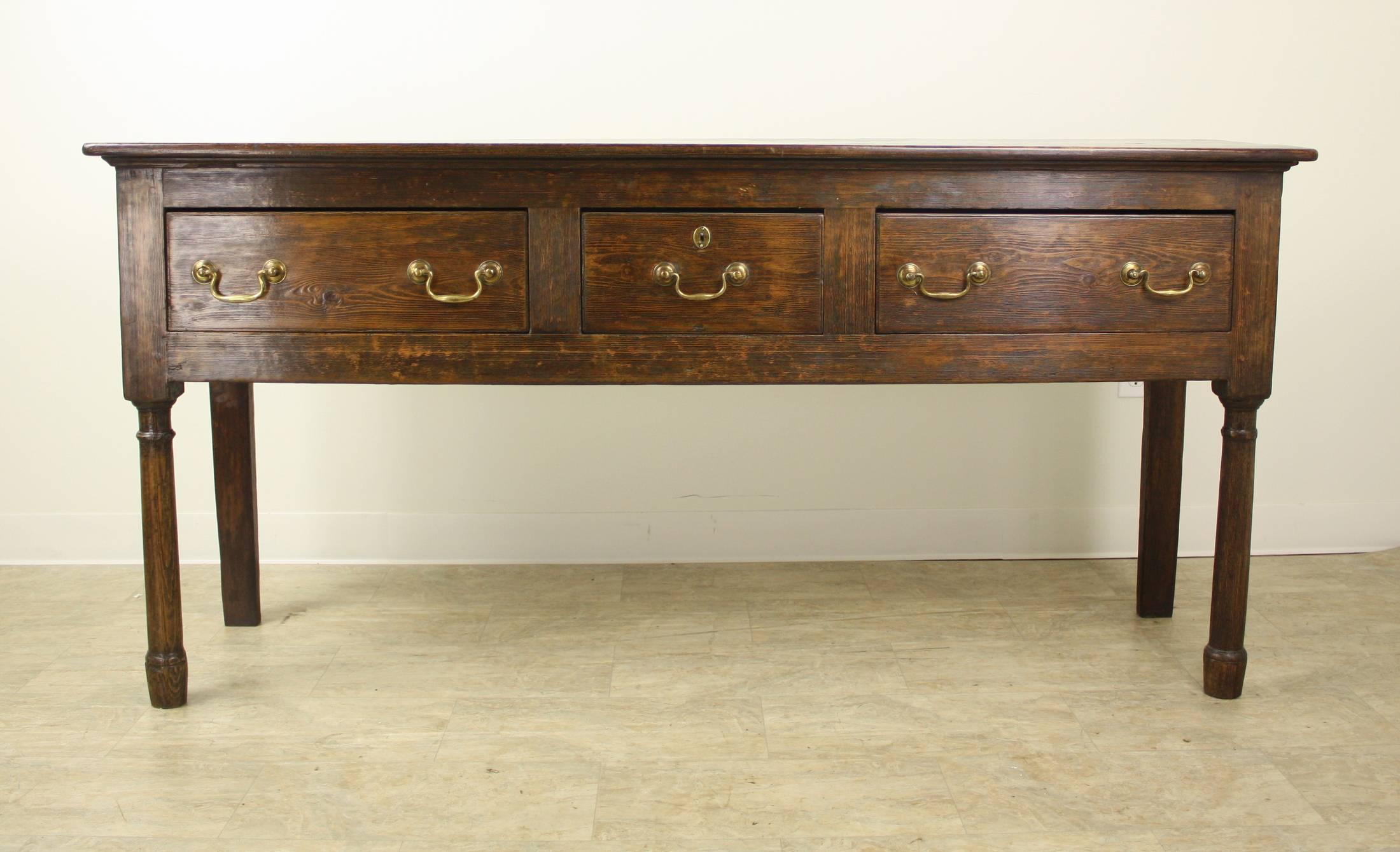 One of our finest servers! This console is an excellent example of Classic early Welsh period furniture, with stylish gun barrel legs, fabulous grain and lovely patina. The three roomy drawers slide easily and are in fine antique condition, as is