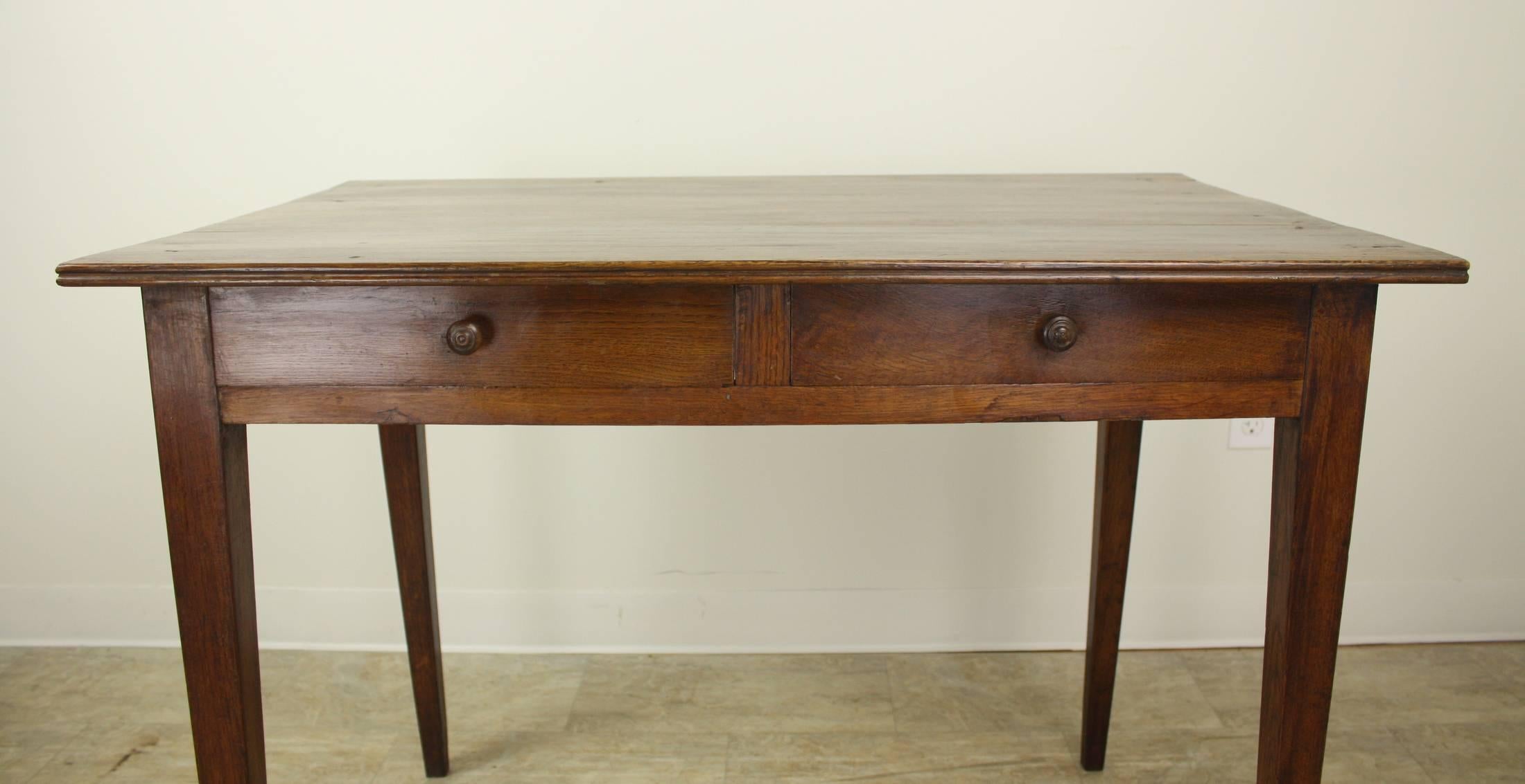 A charming French writing table or small desk in mellow oak. Two small drawers in front add a sweet detail, and the apron height of 25.5" is good for knees. Slender elegant legs and wooden knobs. Perfect!