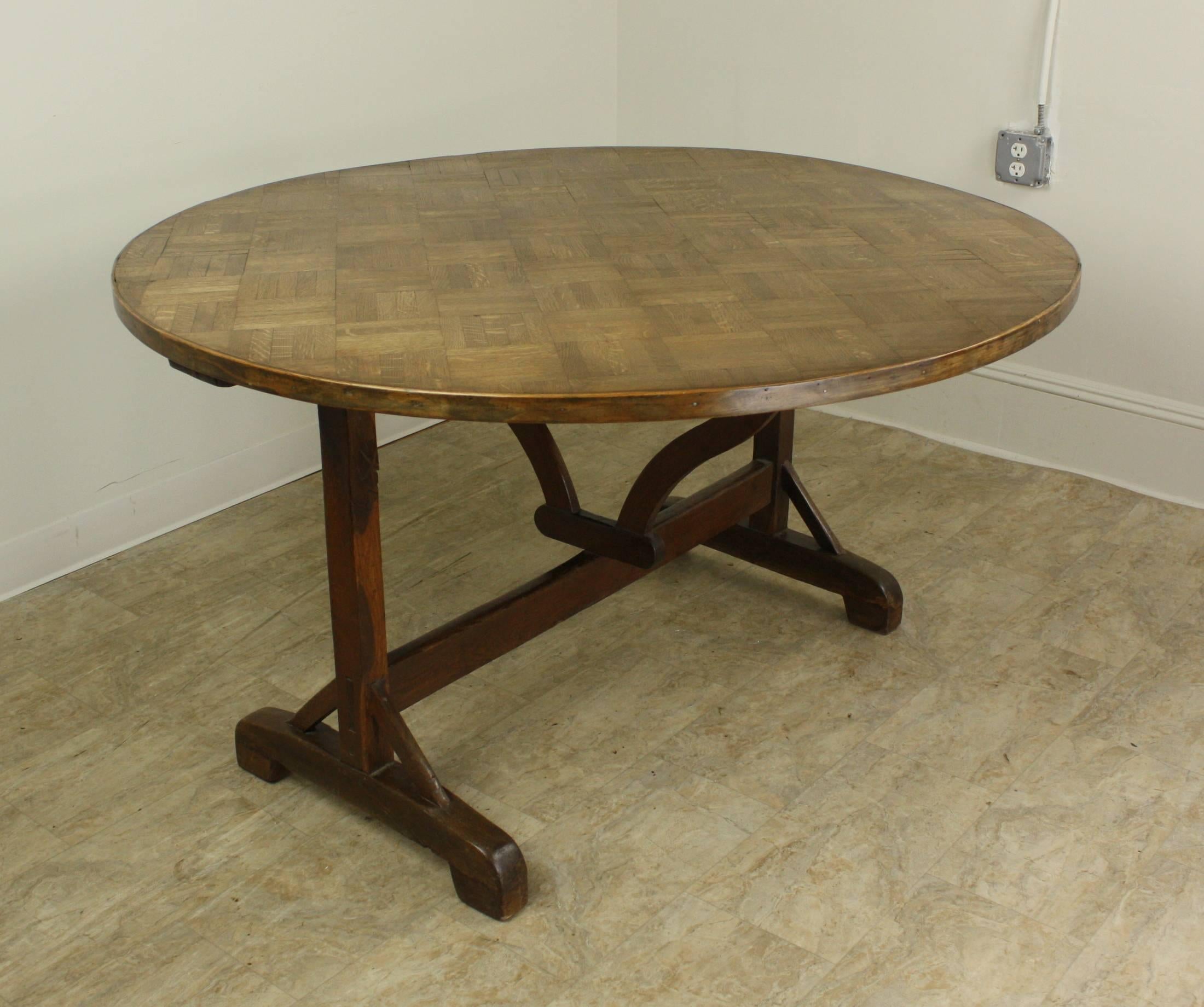 This round tilt top table has an unusual and very lovely parquet top, lightly waxed for contrast but otherwise unparalleled in its natural beauty. Pretty decorative band around the top. The harp base, well colored and with good shine and patina,