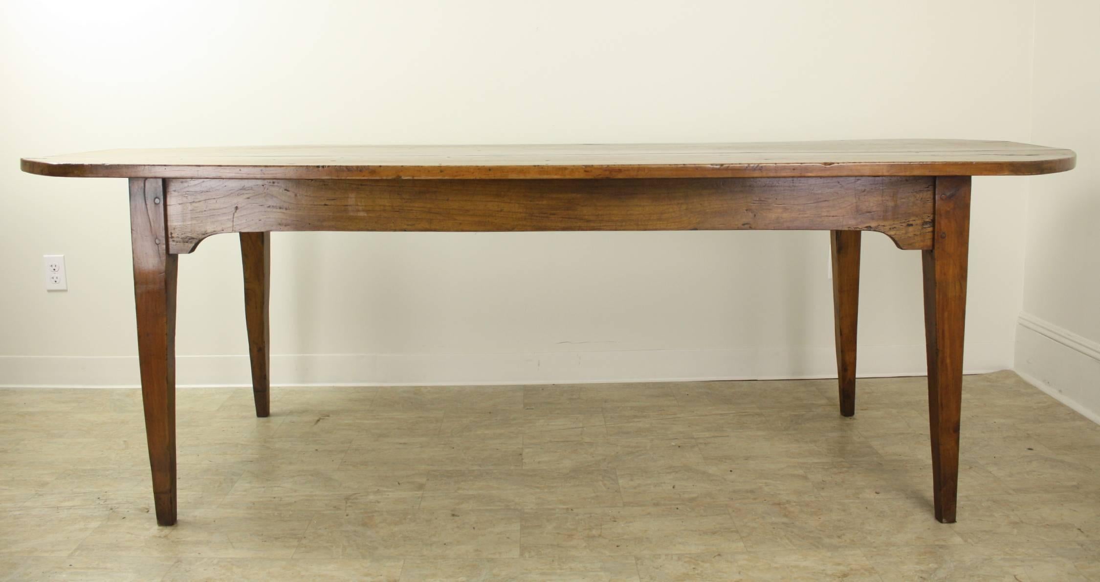 A spectacular long "D-end" farm table with great mellow color and patina. The apple wood has lovely soft graining as well. The "D-end refers to the rounded end of what is basically a rectangular table. This ensures maximum seating.