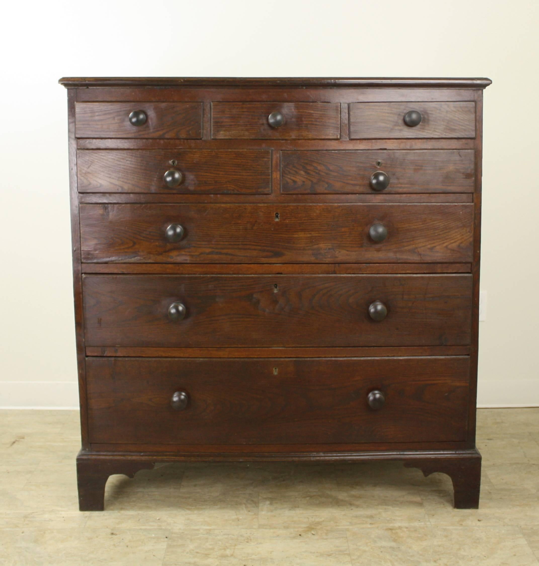 An early dark oak chest of drawers, with nice rich color and patina. The design of the piece, with three drawers over two over three, has loads of visual impact, as well as the practicality of lots of storage. Large round knobs and bracket feet
