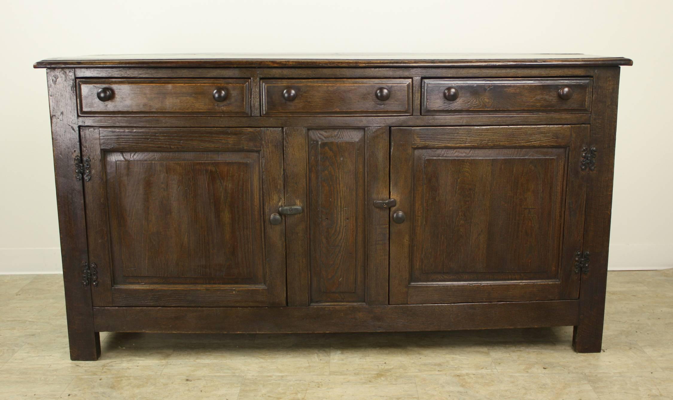 A handsome dark oak server, sideboard or buffet from Wales. The piece has lovely color and is in wonderful antique condition! Latch closures on front doors give a rustic look and close snugly. Interior shelves are not adjustable.