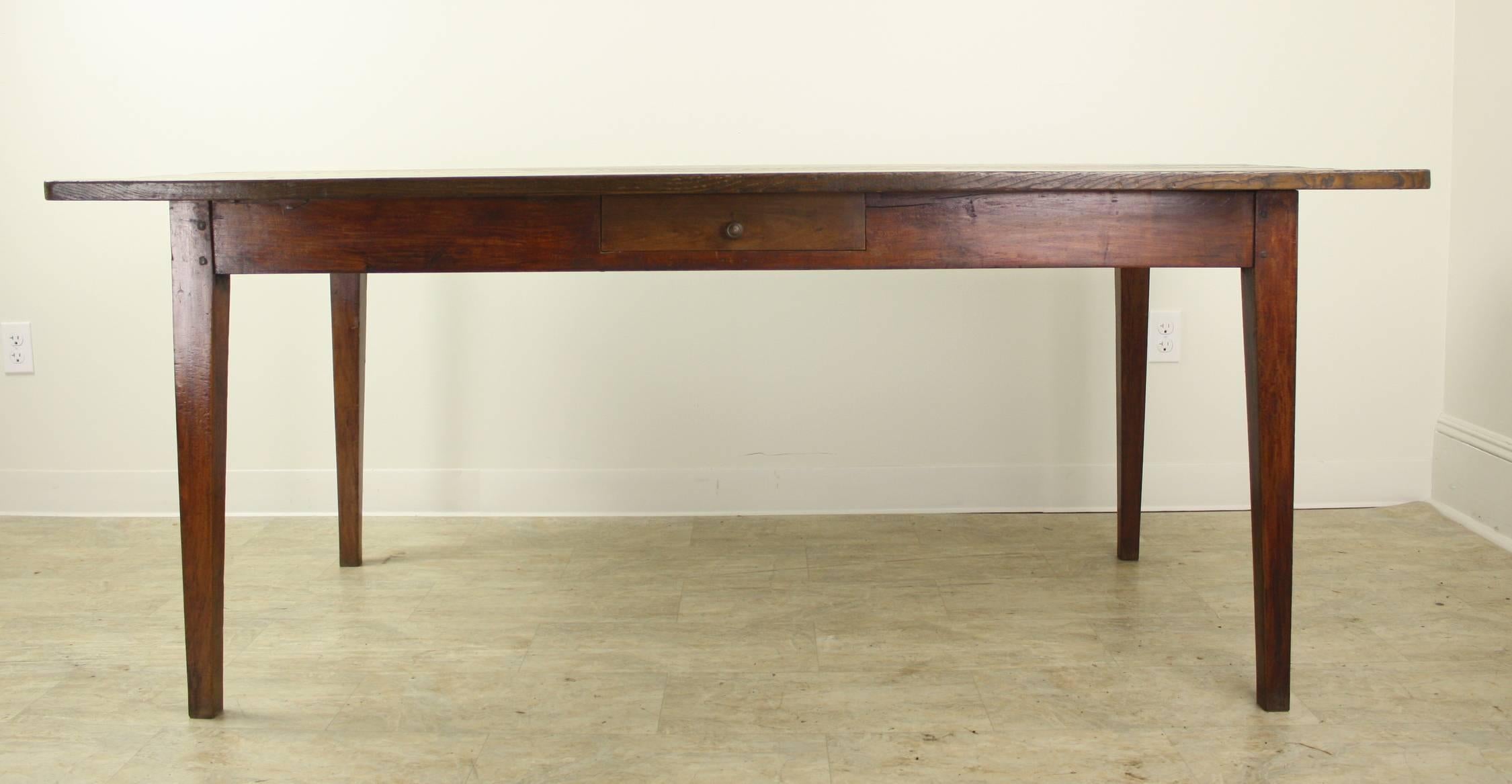 A sturdy and handsome farm table with a mellow chestnut top. Legs are nicely pegged at the apron and 58