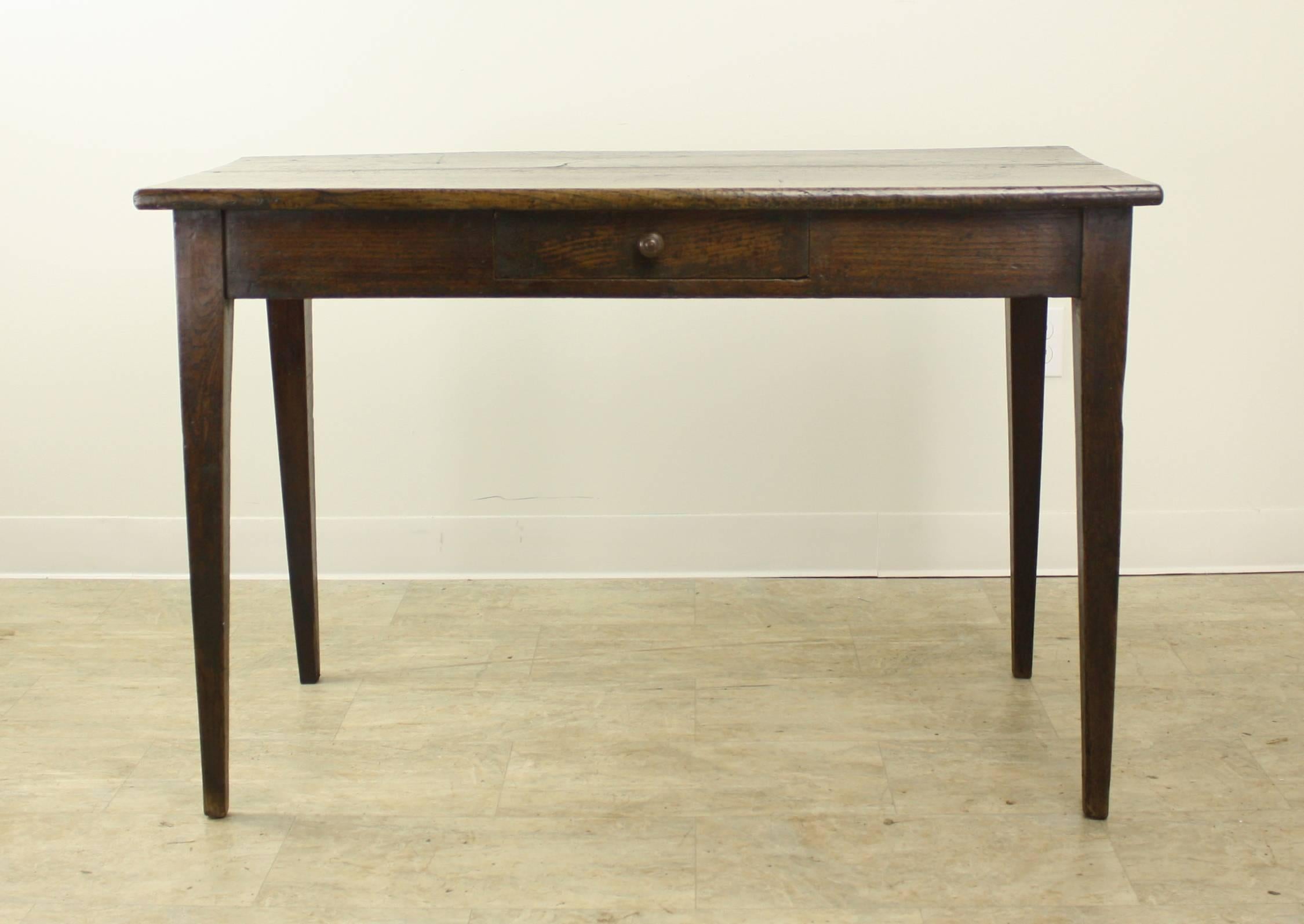 A charming chestnut writing table or occasional table with a shallow depth for smaller spaces. The thick chunky top has wonderful deep brown color and shine. The single drawer adds a note of interest, as well a bit of storage.