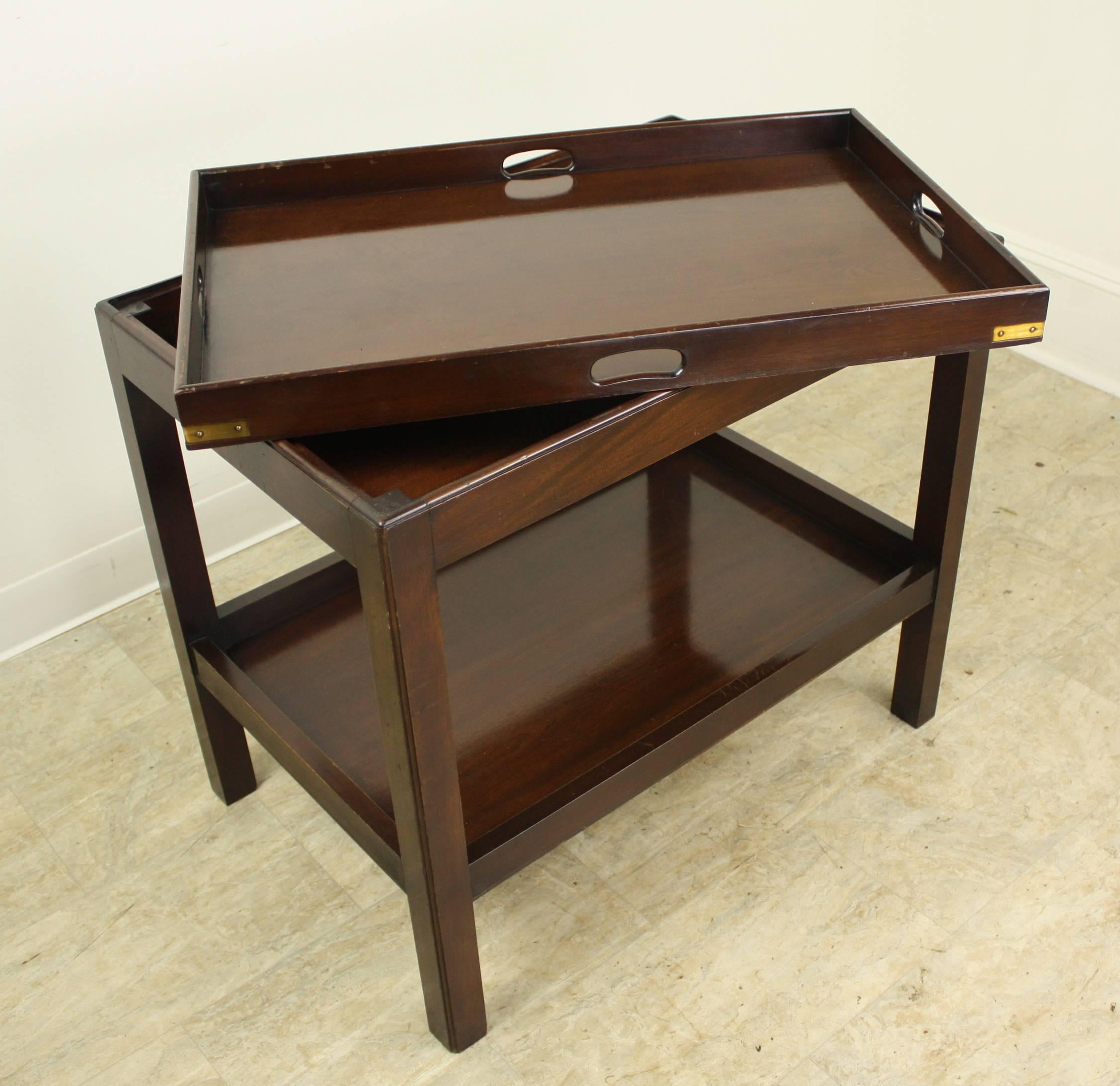 A Classic dark mahogany tray on table. The elegant tray sits well on its base. Easy to lift off and use for serving if desired. Good serving height . Also a good side table or lamp table. Charming brass accents add a note of interest. Some moderate