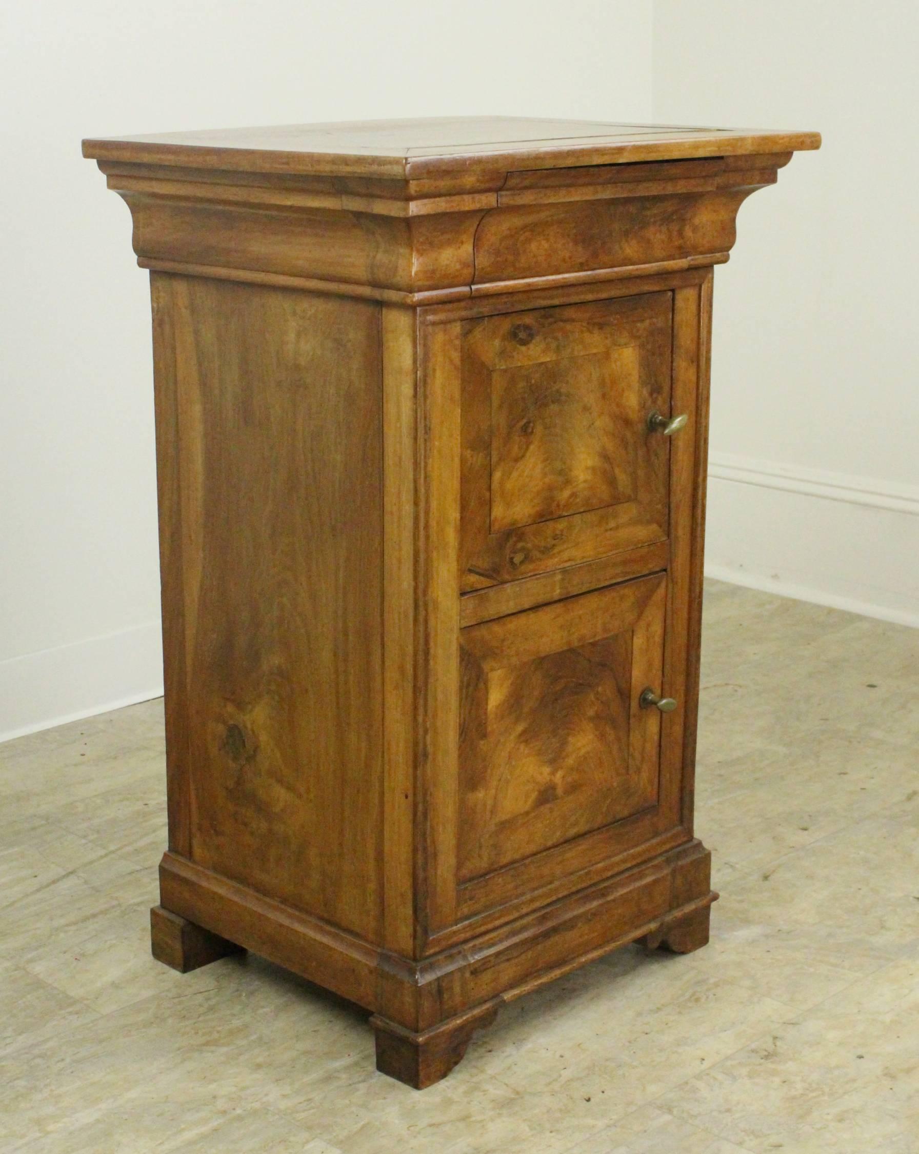A hard-to-find pair of Louis Philippe walnut nightstands. Dramatically colored and grained tops, doors and sides. Classic mouldings and hidden top drawers, as well as mitred corners on the tops. The wood has fabulous patina and glow. Please note