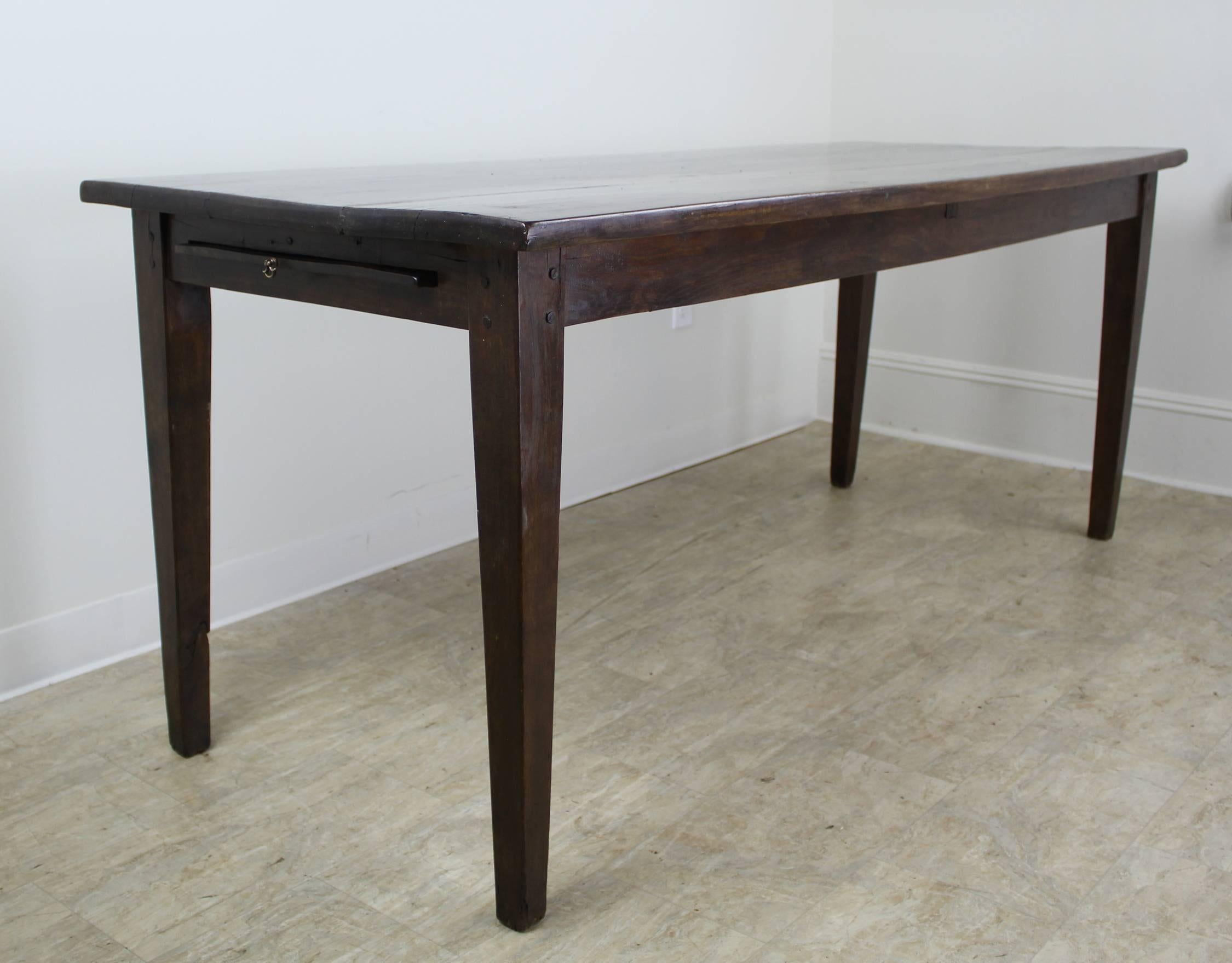 A very Classic farm table, beautiful chestnut wood in the perfect color, with very nice graining and patina. Because the legs are all the way to the ends of the top, the configuration maximizes seating, allowing three chairs on each long side, with