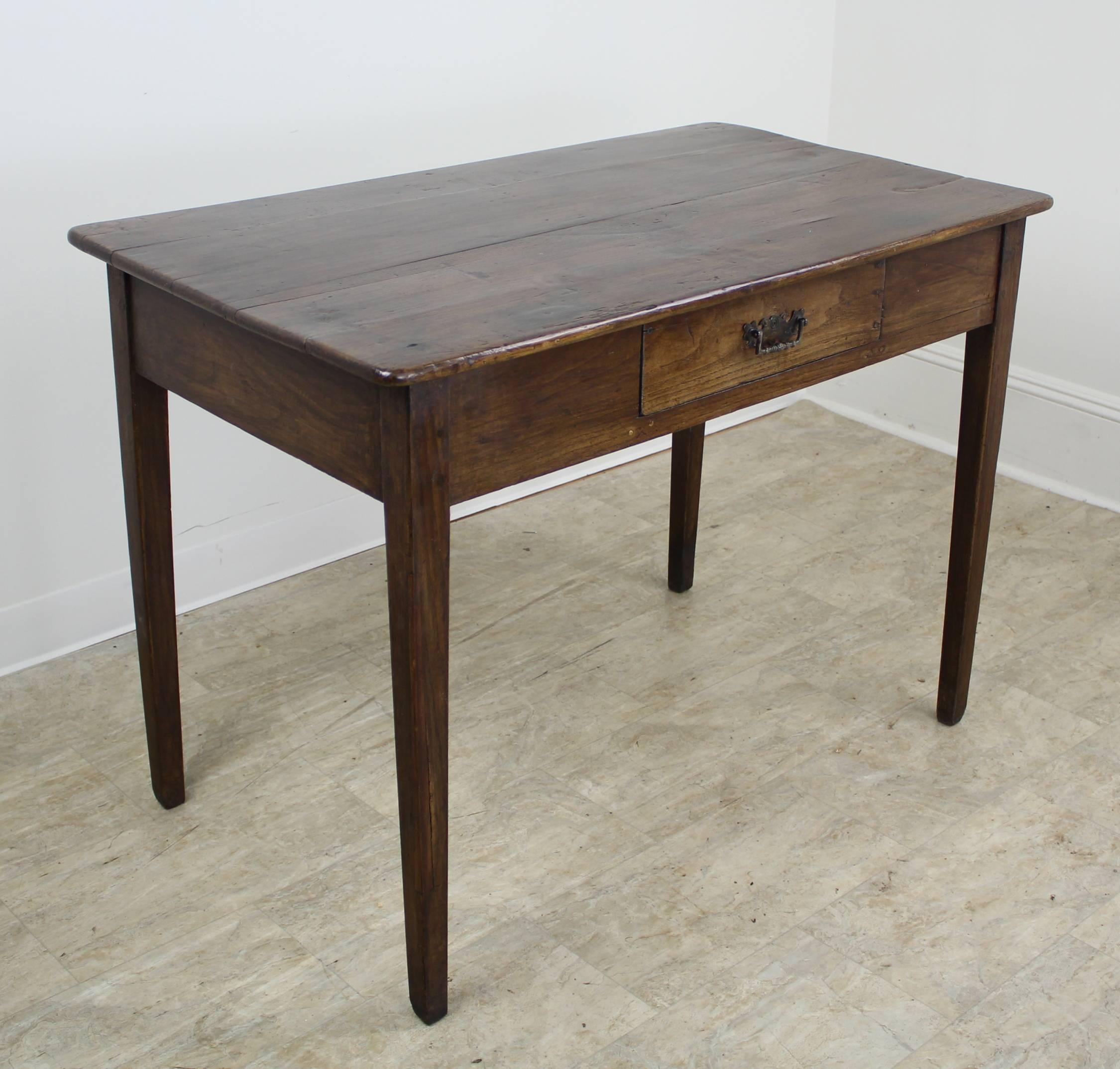 A great country looks in a good medium to large size desk. Handsome dark oak with an excellent patina. One drawer with decorative, ornate pull. Classic tapered legs. Charming piece. Apron height is 24" allowing good knee room.