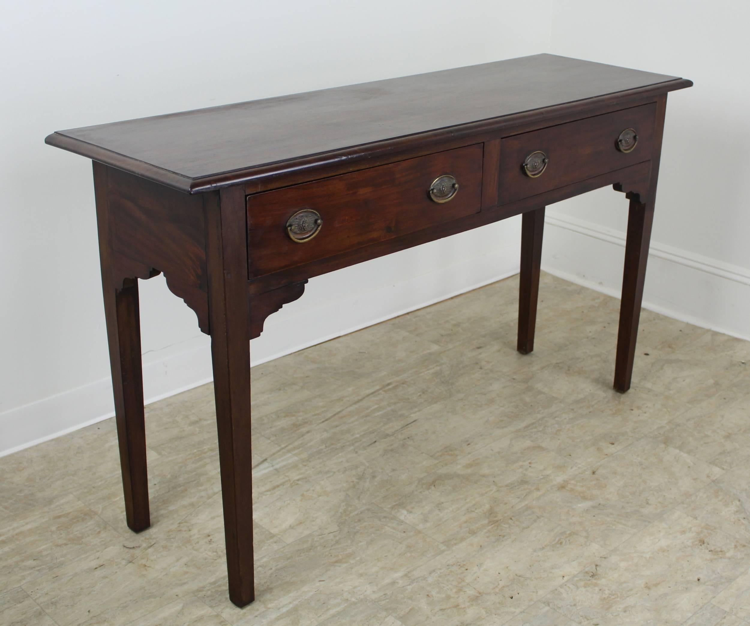 A wonderful walnut sideboard from England, circa 1860. Charmingly proportioned with beautiful color and patina. The perfect size for a smaller city dining room or entrance hallway. Both the beautiful walnut grain and the decorative carved supports