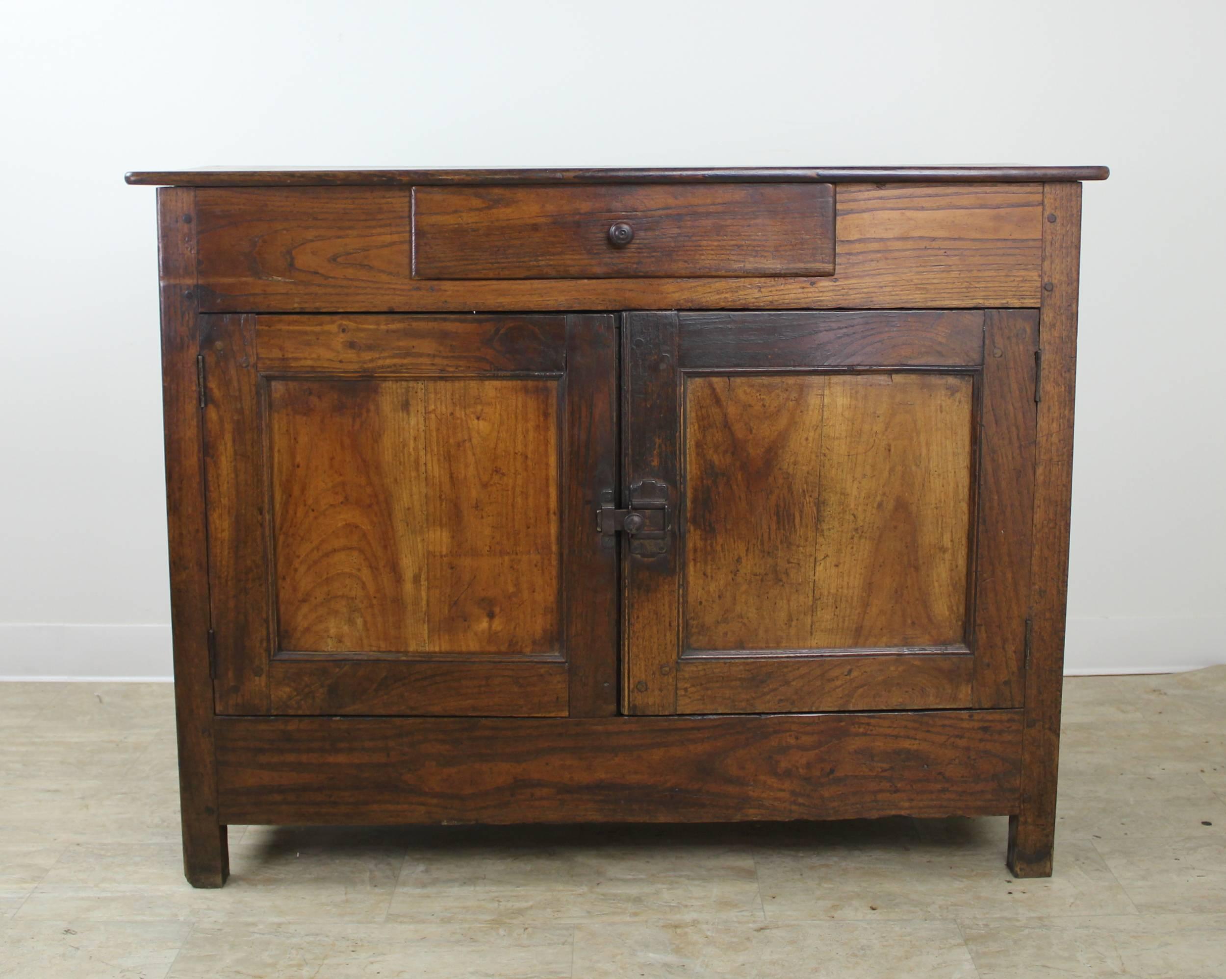 A simple and handsome chestnut server, sideboard or buffet from France. The piece has lovely grain and is in wonderful antique condition! Inset panels on doors and sides add visual interest. Iron latch closure gives a rustic look and closes snugly.
