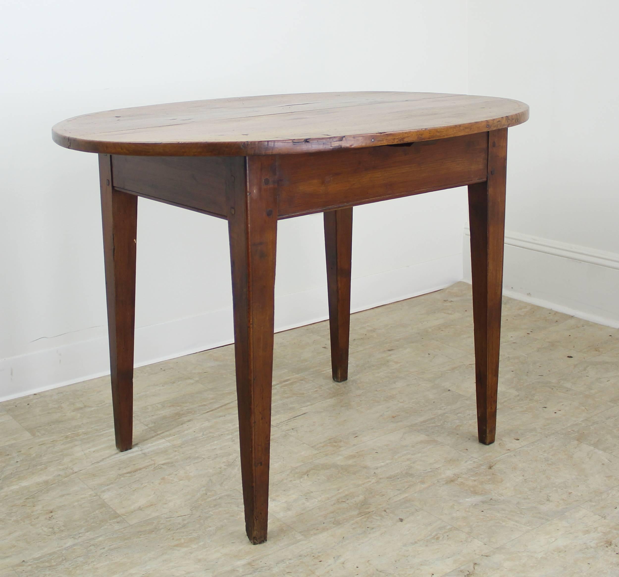 A charming occasional, lamp or end table in warm cherry with elegant tapered legs. Legs are nicely pegged at the apron and the top has wonderful color and patina. There is a small patched area on the top.