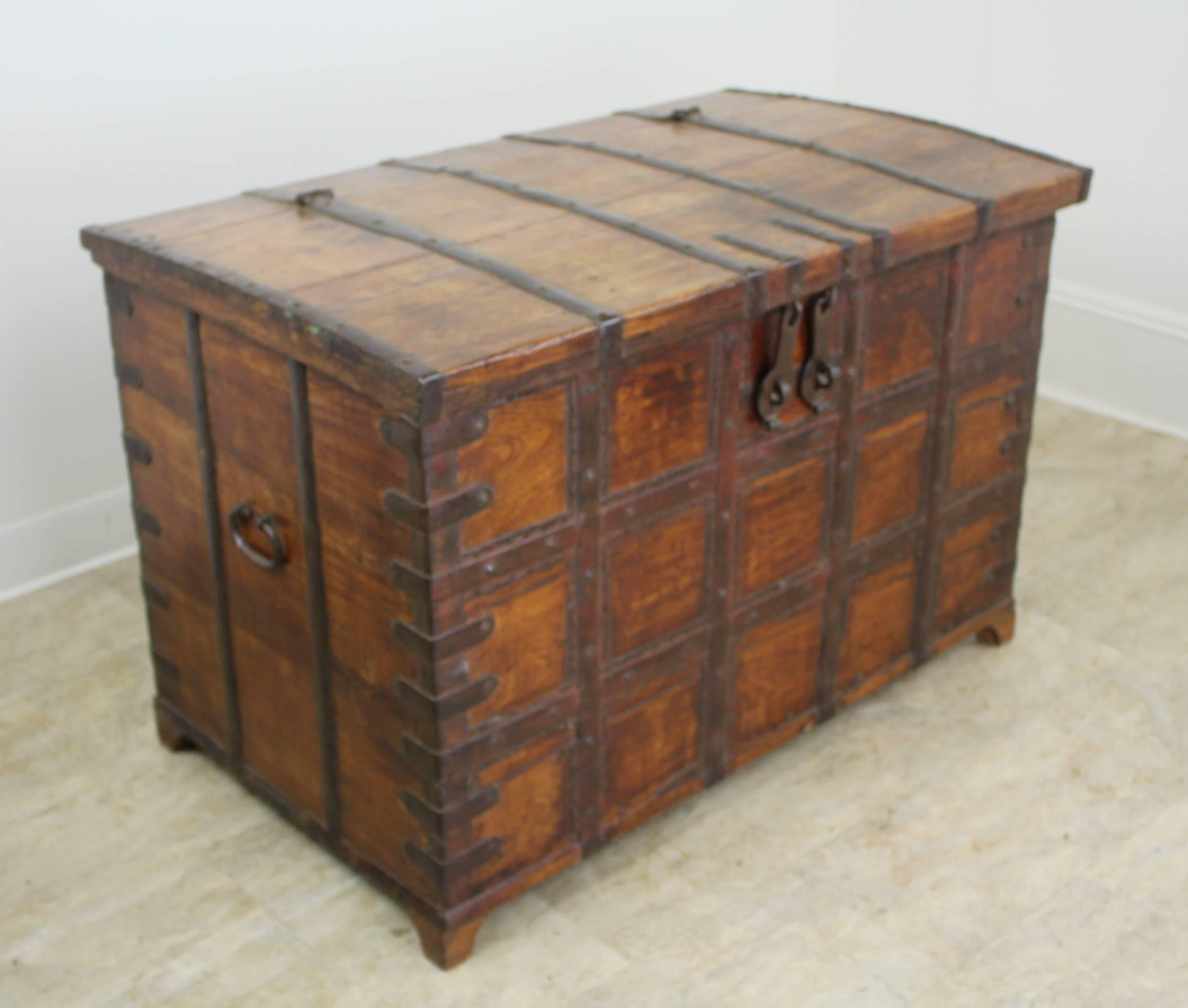 An early French trunk or blanket chest, with highly decorative iron strapping and hand-wrought iron handles. The front and sides of the piece have their original stain and vanish, worn to a glow. The arched top also has great patina and natural