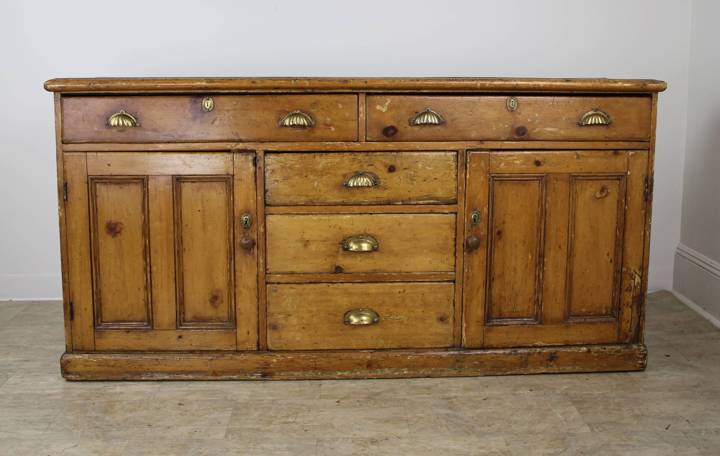 A fabulous Welsh pine cupboard, sideboard or dresser base with some of the most glorious patina and character we have seen. Gorgeous honey colored pine, polished to a glow. Outset panels at either end add a nice design note. All of the five roomy