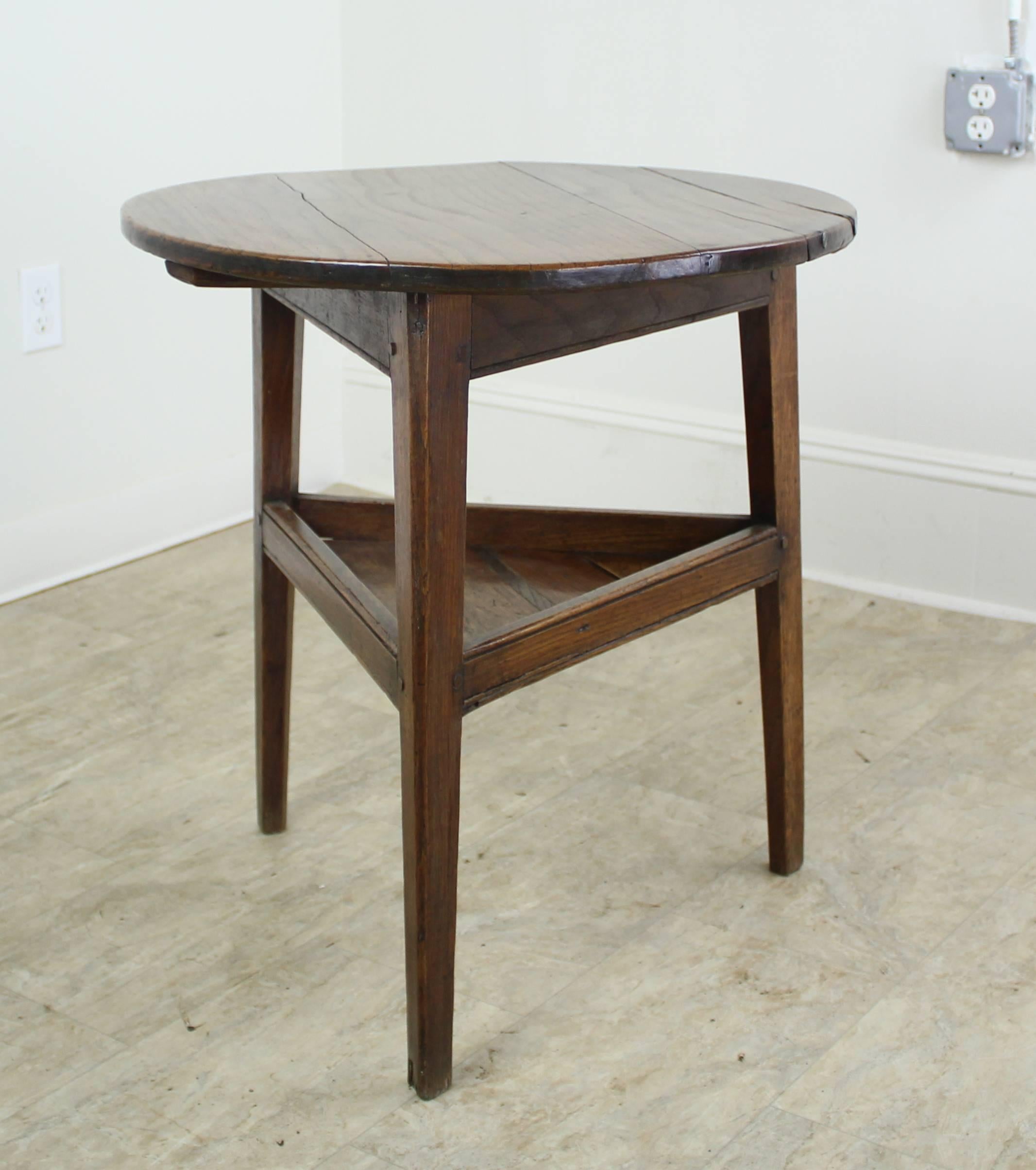 A charming small cricket table in mellow oak with lovely patina. This height of this table makes it right as a lamp, side, end or occasional table. The color and fine grain lend texture and interest to any decor. Lower shelf adds storage and a