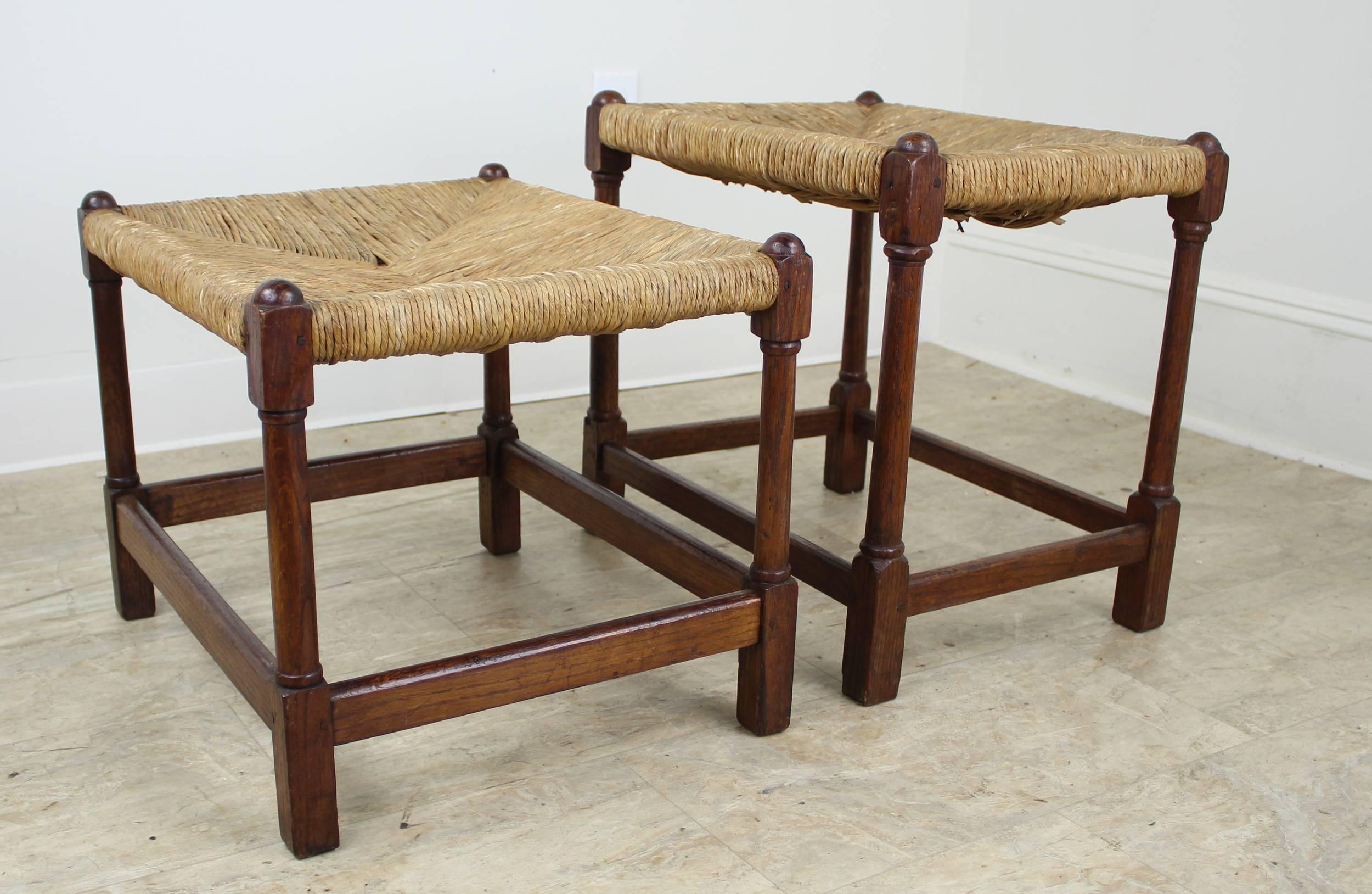 A pair of sweet little oak rush-seated stools for the hallway, living room, child's bedroom, or as perches on either side of the fireplace. Measurement below is for the taller stool. The smaller one measures 19 inches wide by 15.75 inches deep by 15