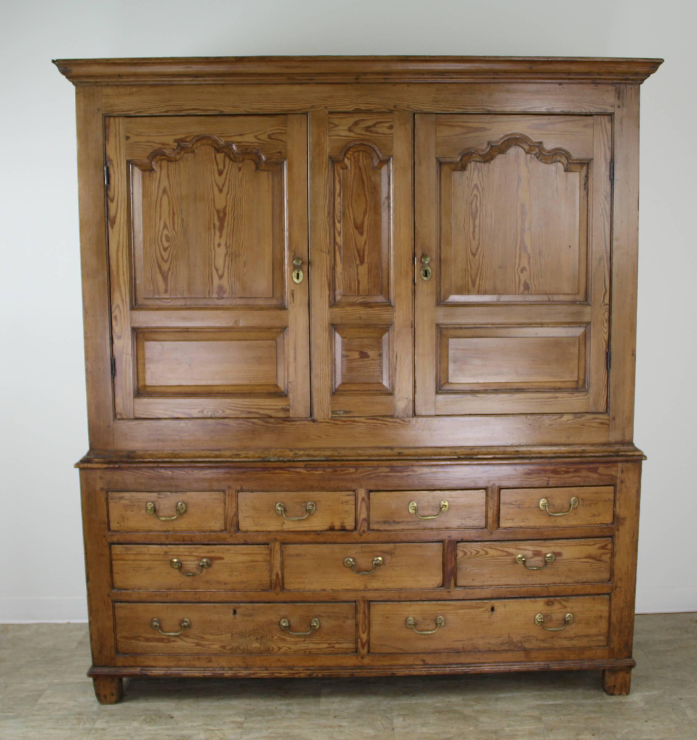 A gorgeous antique Welsh linen cupboard or wardrobe in honeyed pine with good textured grain. Features include crowd molding at the top and centre, inset panels on the sides, and four-over-three-over-two-drawer construction. The interior of the