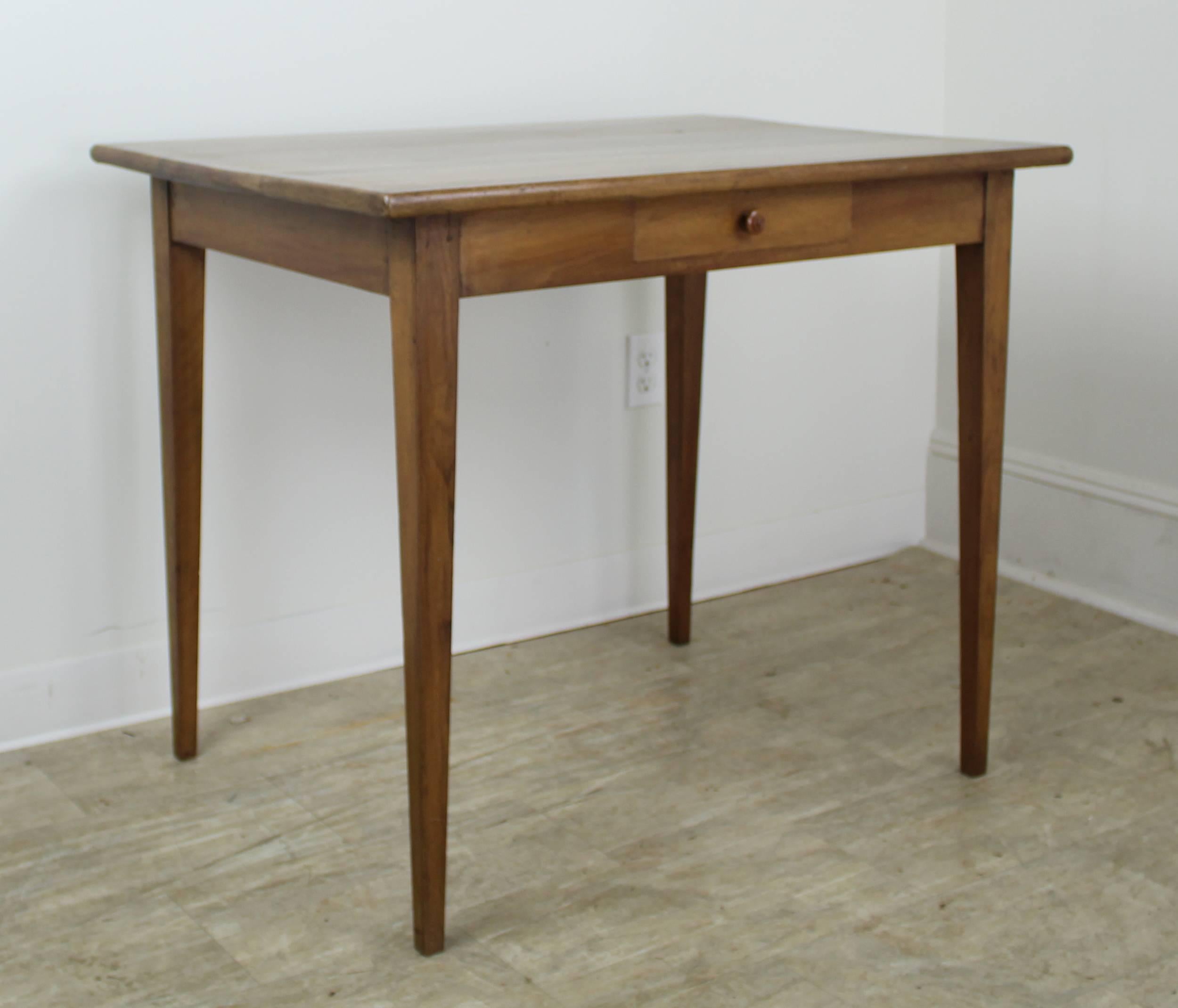 A pretty writing or side table in light walnut with a dramatically grained top. The thin tapered legs and high apron of 26 inches give this desk an elegant silhouette that would work with any decor. Image #6 shows the hand cut, naturalistic edge to