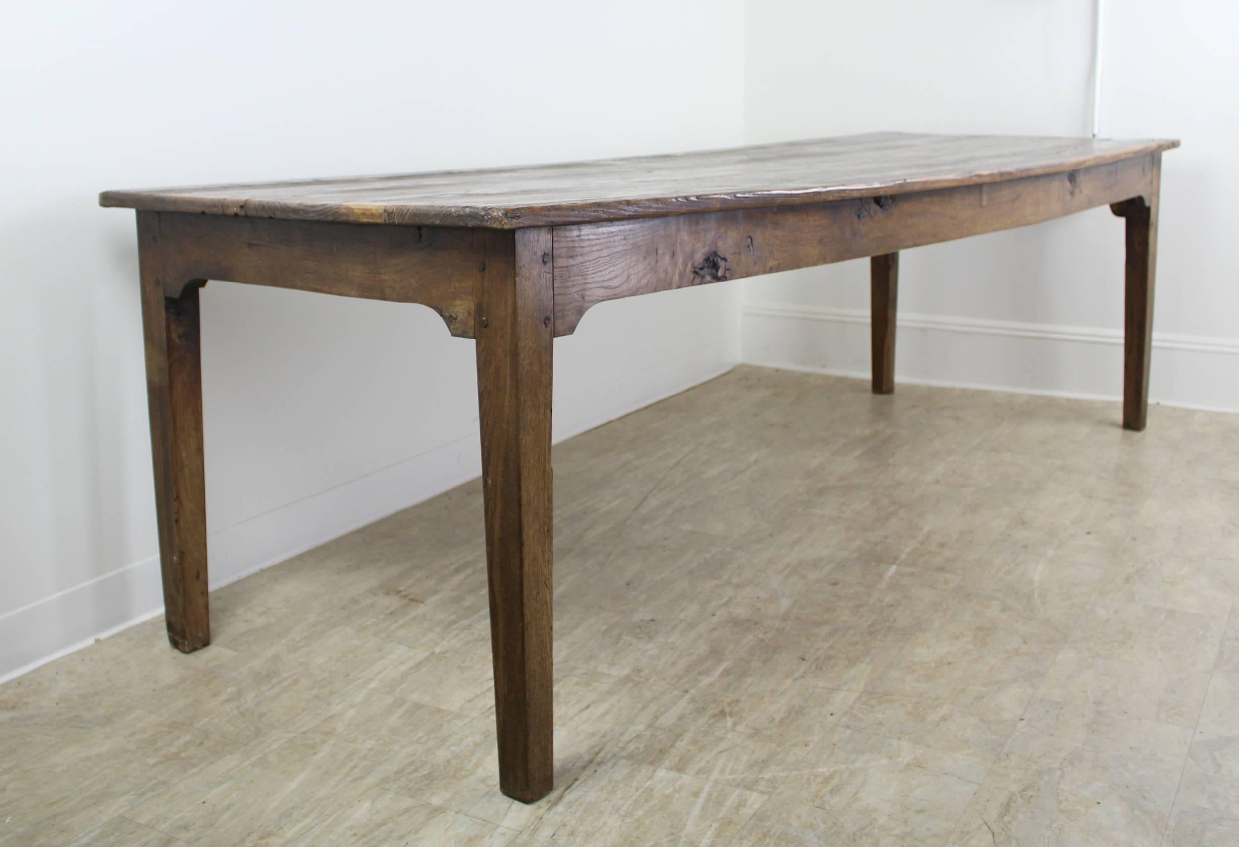 A long rustic pine farm table with glorious pine grain and natural knot holes. The color and patina on this piece are really good. With 92.5 inches between the legs on the long side, this table can seat ten. The apron height of 24.5 inches is good
