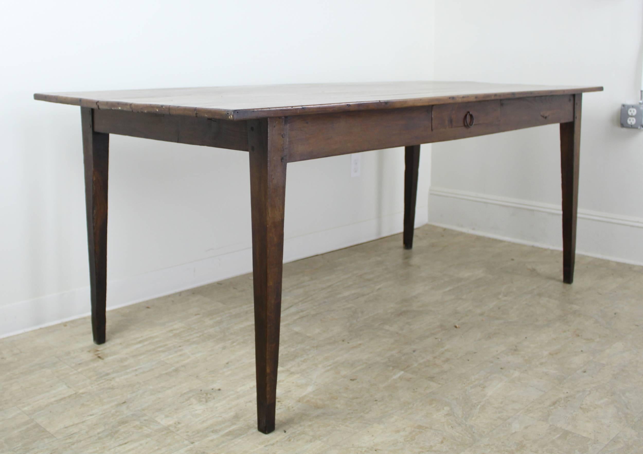 A lovely warm cherry farm table with a very good depth for a piece of its age. Between the 35 inch depth and the 25.75 inch apron height, lots of room for knees! Pretty color and patina with age appropriate distress and classic slim tapered legs.