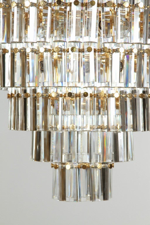 Grand seven-tier faceted prism chandelier. 
The beautiful polished brass armature supports the faceted glass prisms which when illuminated make this a truly stunning chandelier.
