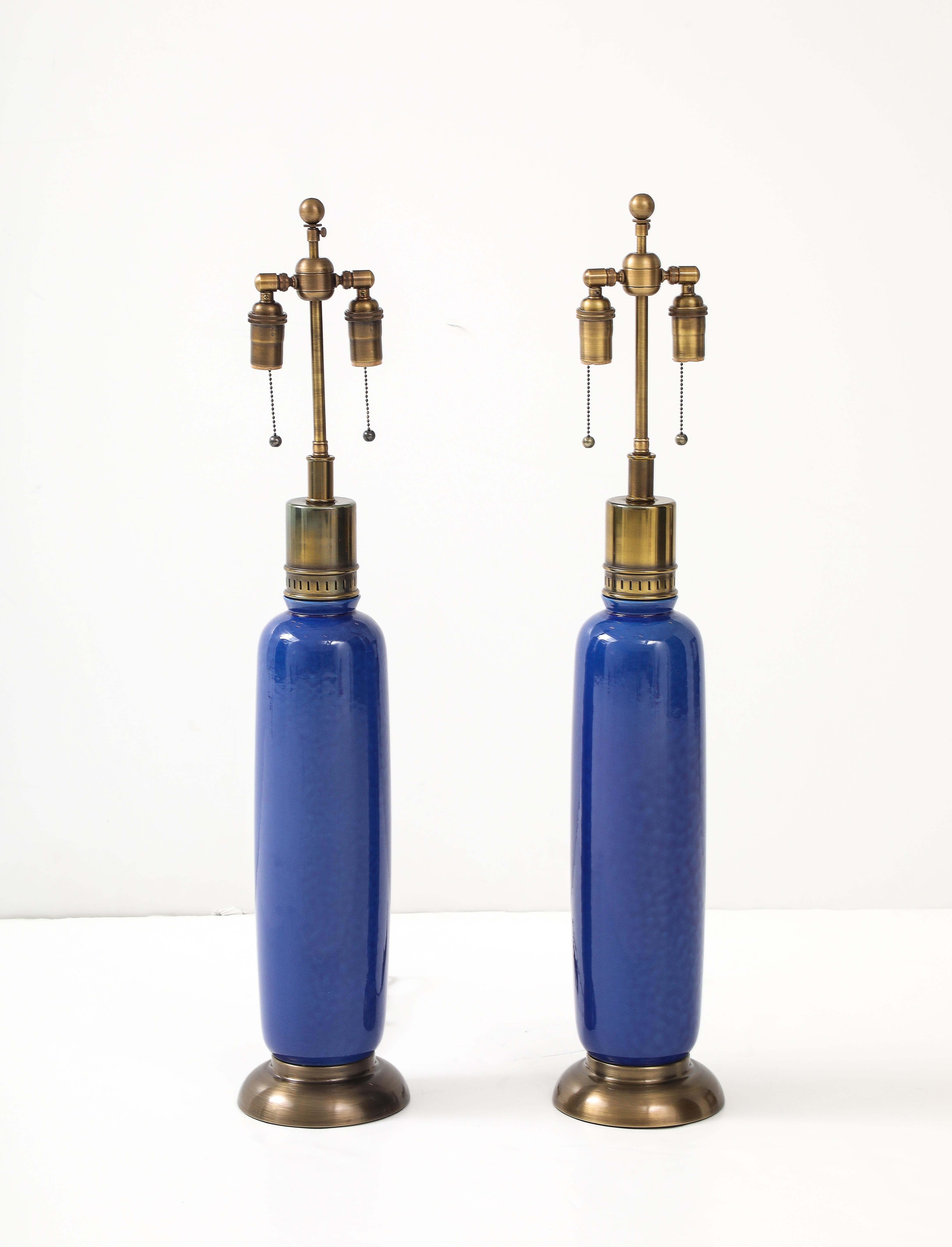 Paire de lampes hautes en céramique italienne des années 1960, avec une belle glaçure bleue tachetée.
Les lampes sont dotées d'une quincaillerie en bronze vieilli et ont été recâblées pour les États-Unis avec des lampes à incandescence. 
doubles