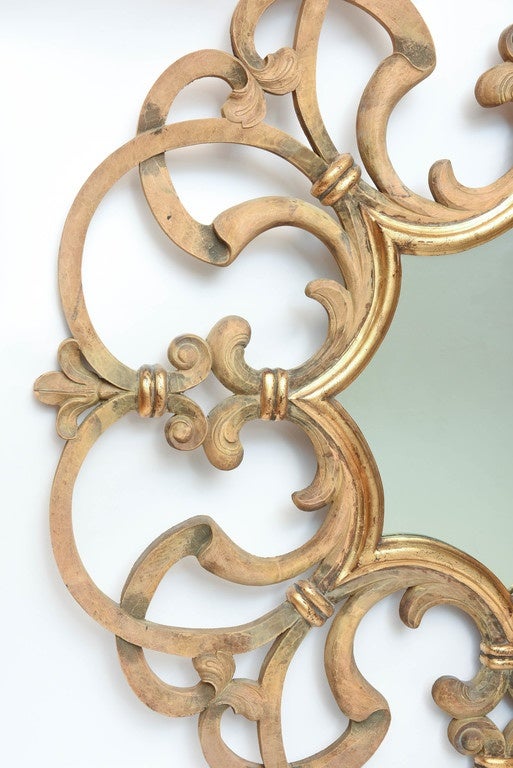 Exquisitely carved and lightly gilded scrolled mirror by Harrison & Gil, master carvers.