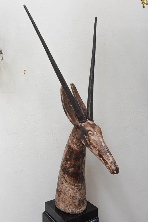 Striking antelope head with removable horns on a black marble base.