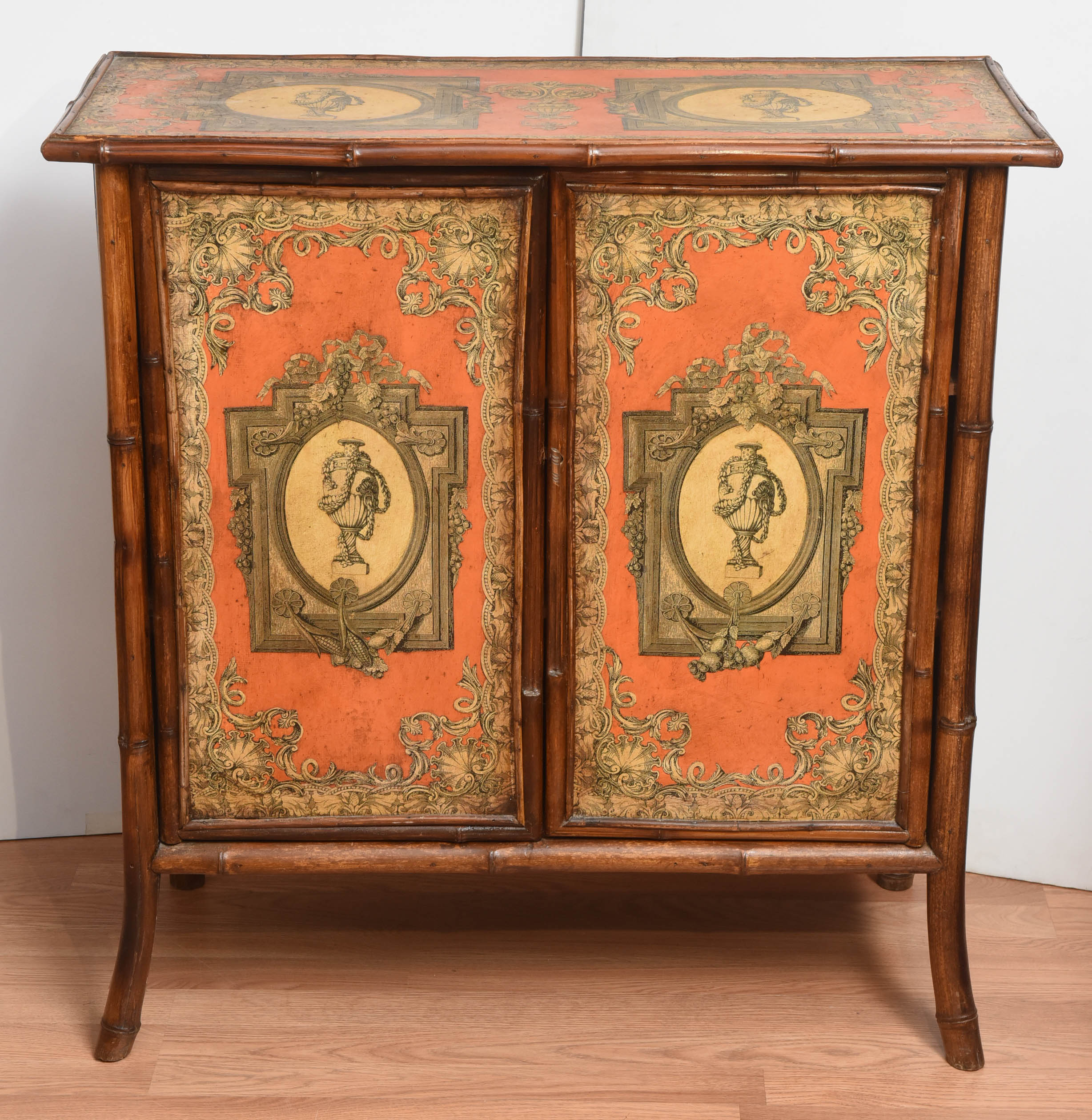 Charming and whimsical antique bamboo cabinet. Fabulous Decoupage décor on a bright coral background.