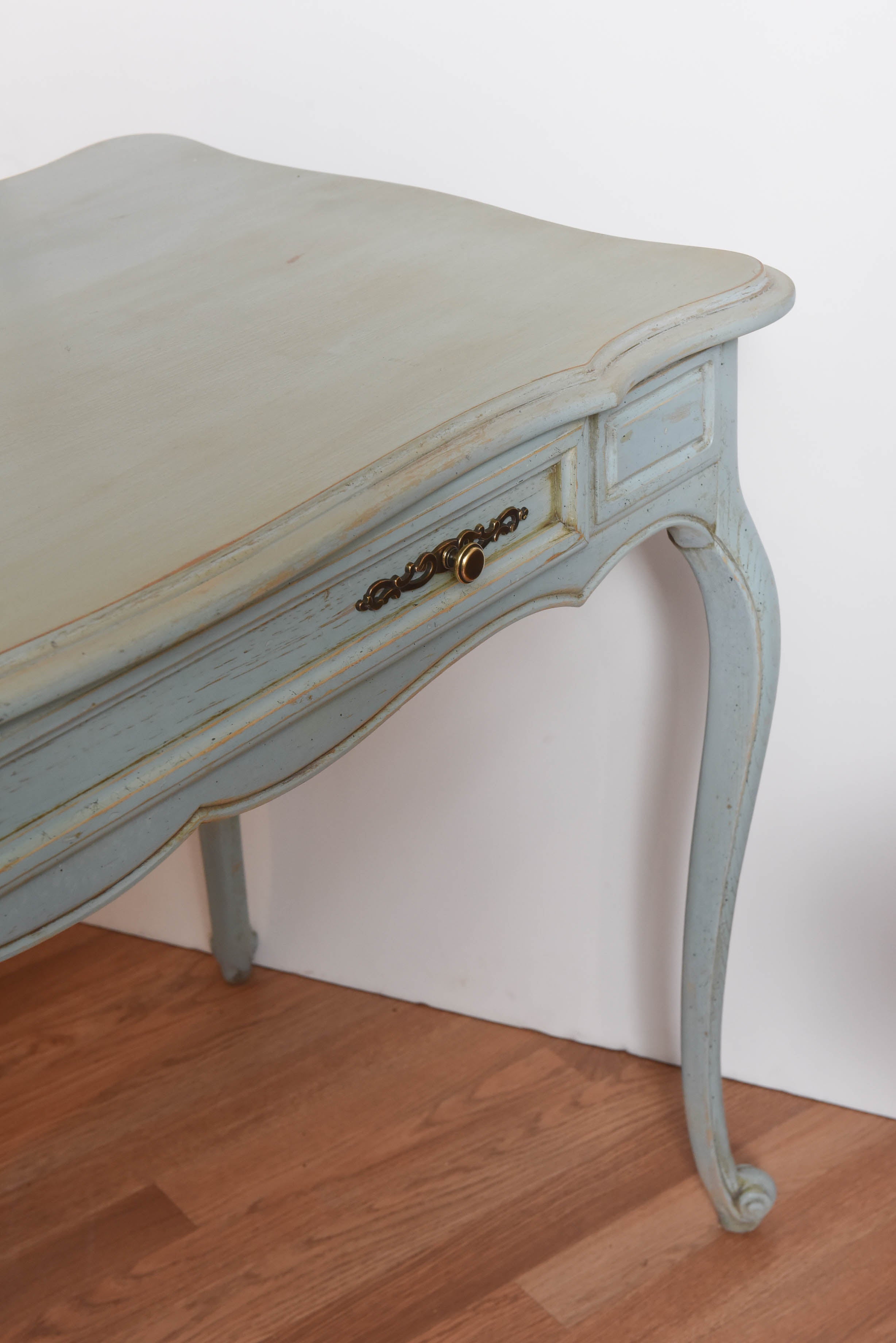 Charming country French blue painted desk.  Usually placed with flat side against the wall, flanked by two chairs.  Drawer opens to either side.