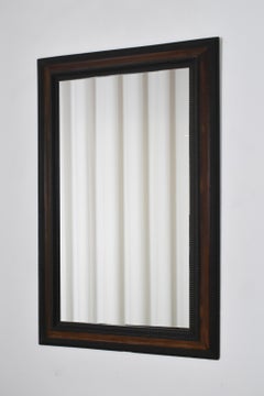 Carved ebonised wood mirror and trompe l'oeil turshell, XIXth c.
