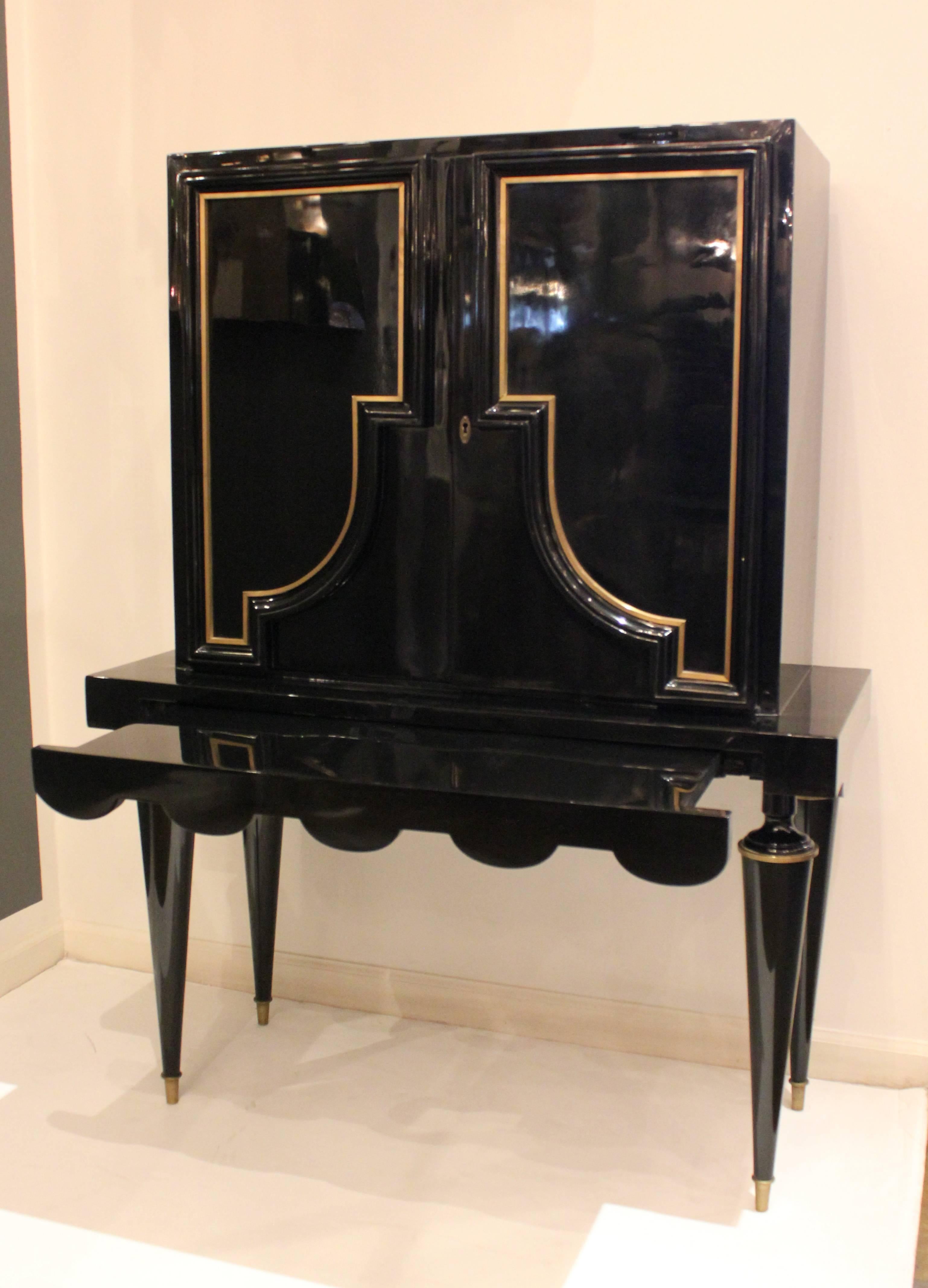 Black lacquer Arturo Pani cabinet with brass inlay. Recently restored.
Two doors with interior hardware to hang glassware. Scalloped pull-out shelf
1940s.