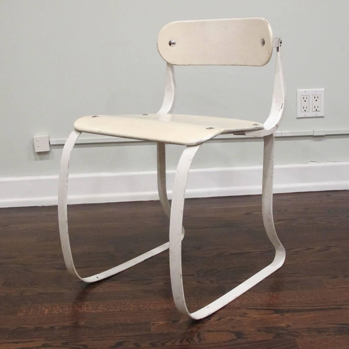 Iconic white-painted wood and steel side chair with pivoting back designed by Herman Sperlich in 1938. The chair has a mostly-original white painted finish but has been touched up at some point. There are minor cracks to the plywood seat visible in
