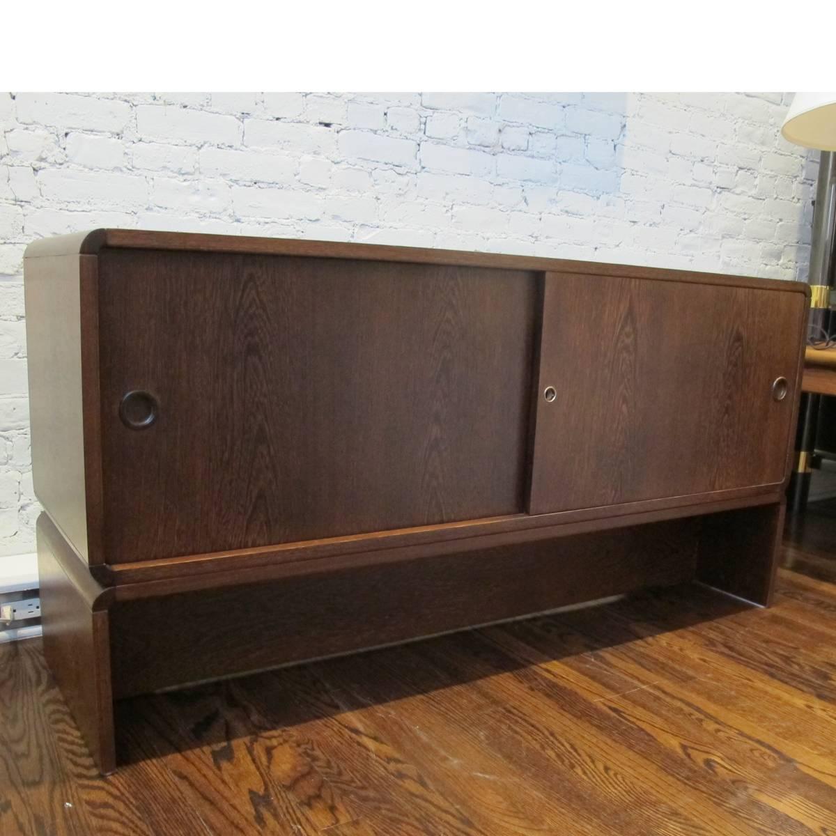 Small, low credenza designed by Martin Visser for Spectrum. Wenge with recessed wenge pulls, the cabinet has two sliding doors concealing two cabinets with adjustable shelves. Could be great for under a TV or as an oversized bedside or table.