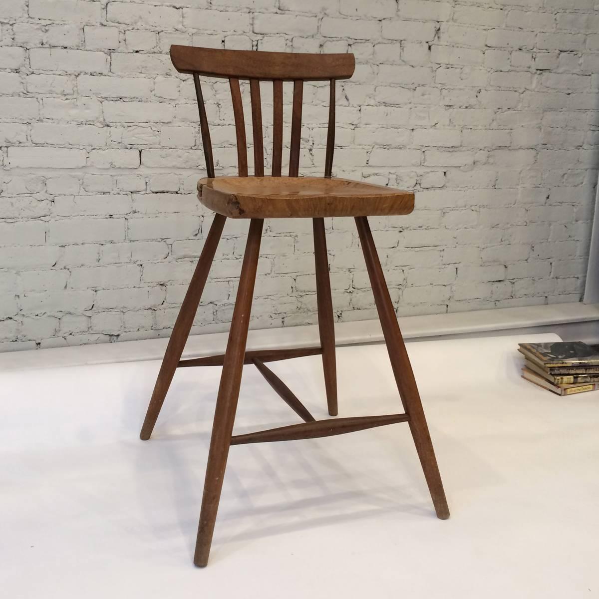 Wharton Esherick- inspired single bar stool with a thick carved seat made from a slab of maple burl, with base and back constructed of solid walnut.