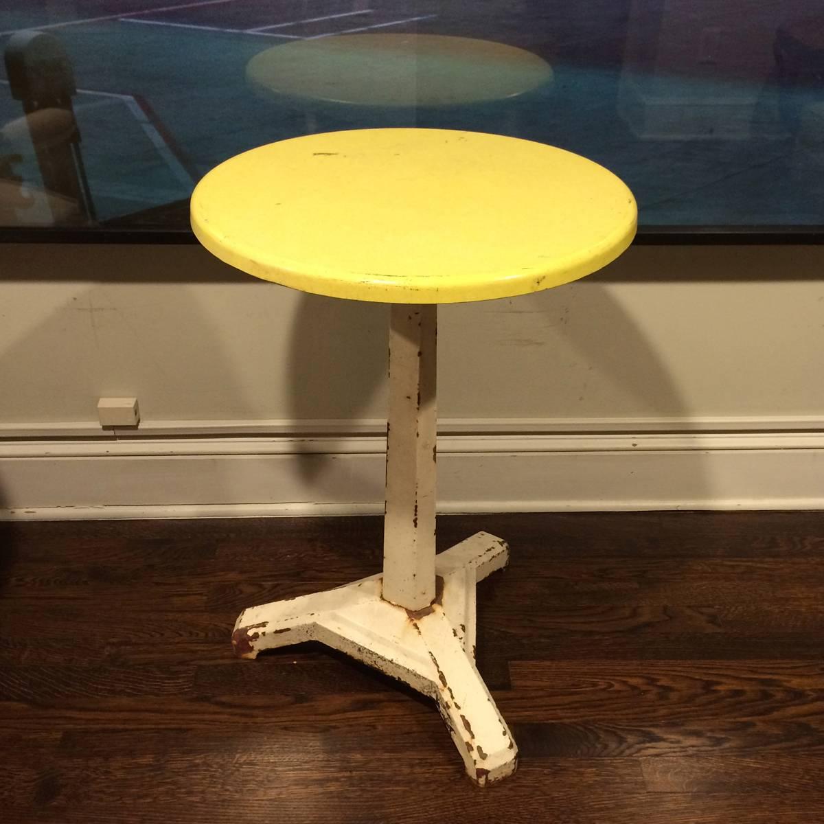 Early 20th century small gueridon or bistro table that may be used in an indoor or outdoor setting like a patio or terrace. The flexible size is great for dining, kitchen, end or center table. The substantial yellow bakelite top is attached to a