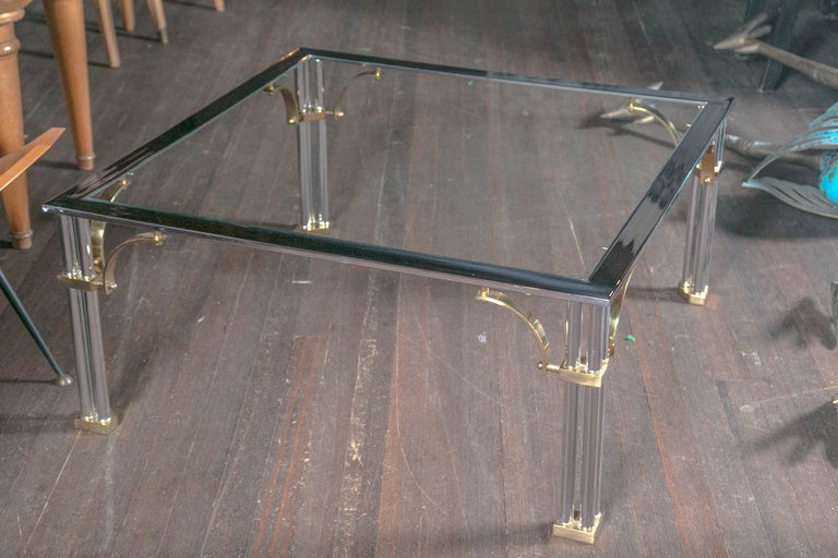 Square brass and chrome glass top cocktail table.