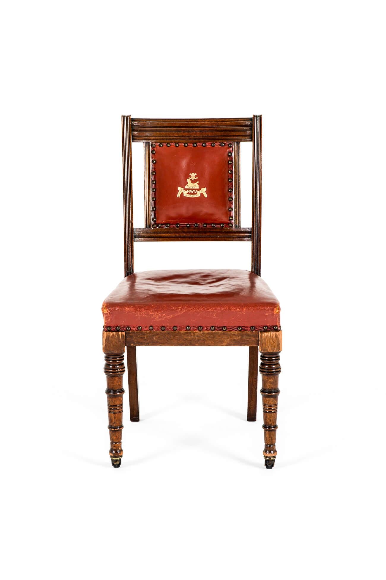 Rara poltrona vittoriana in mogano di Ralph Johnson, Warrington, Inghilterra.

Il sedile è imbottito in pelle rossa.  con il dorso decorato e dorato con le insegne del First South Lancashire Regiment.

Sia il sedile che lo schienale sono abbottonati