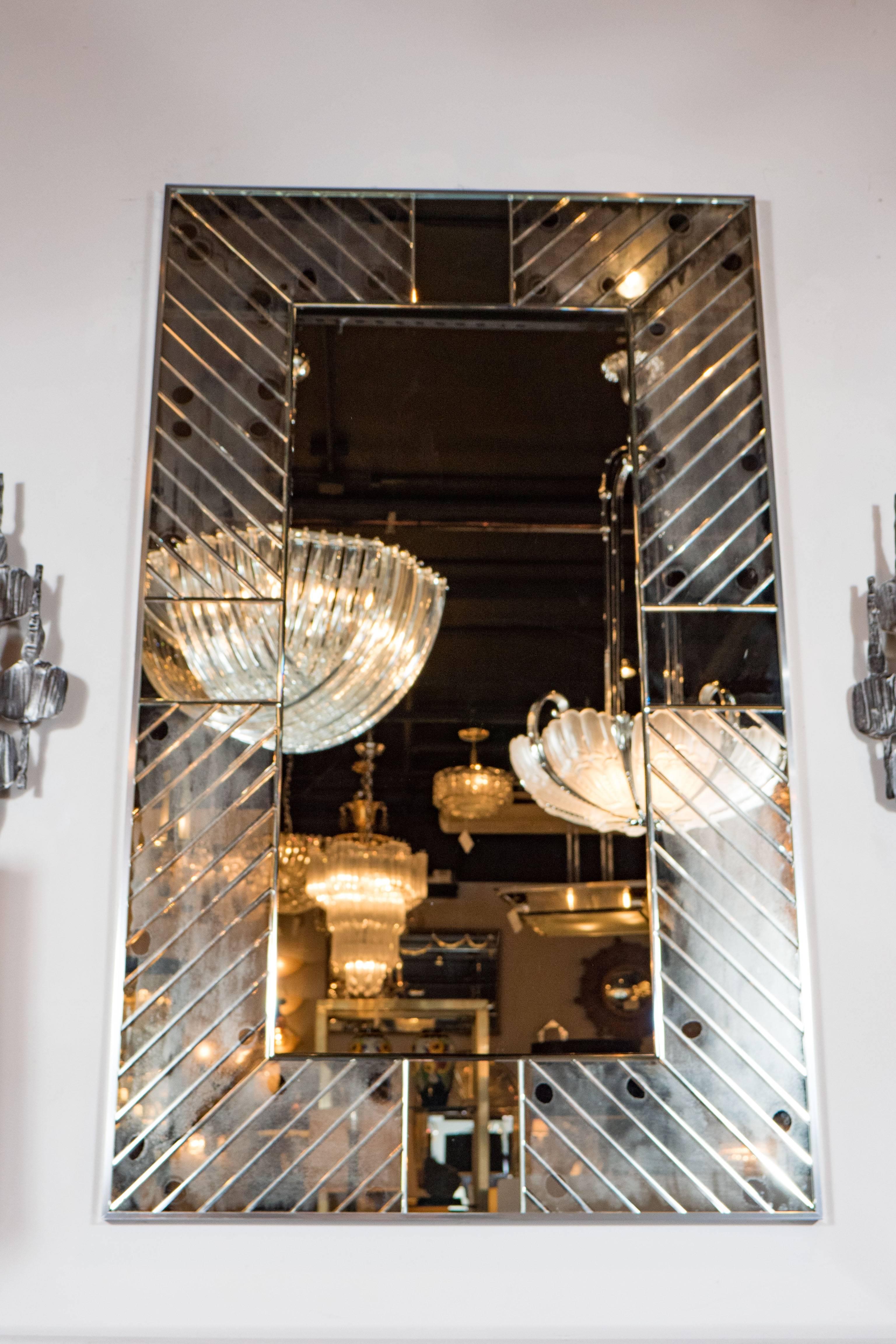 A stunning Tommi Parzinger Originals Model #208 segmented mirror in diagonal patterned glass. A central portion of rectangular mirrored glass is framed by symmetrical segments of patterned cut glass. Each piece is hand-beveled. Exquisite