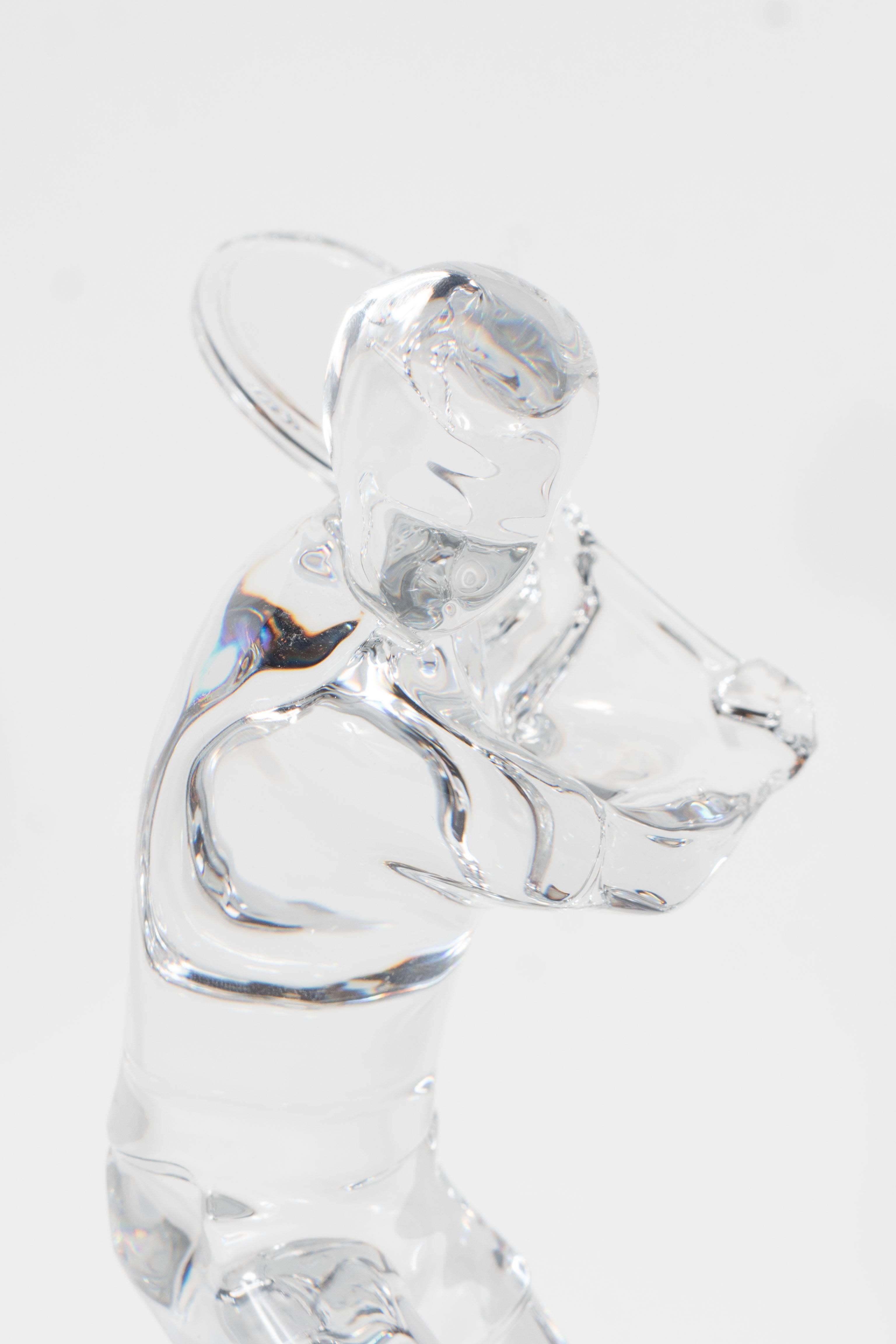 A Baccarat figurine depicting a tennis player preparing to hit a one-handed backhand. This would be a perfect sculpture for any tennis enthusiast, or for a sports lover looking for an elegant glass sculpture to adorn a cocktail table or office desk.